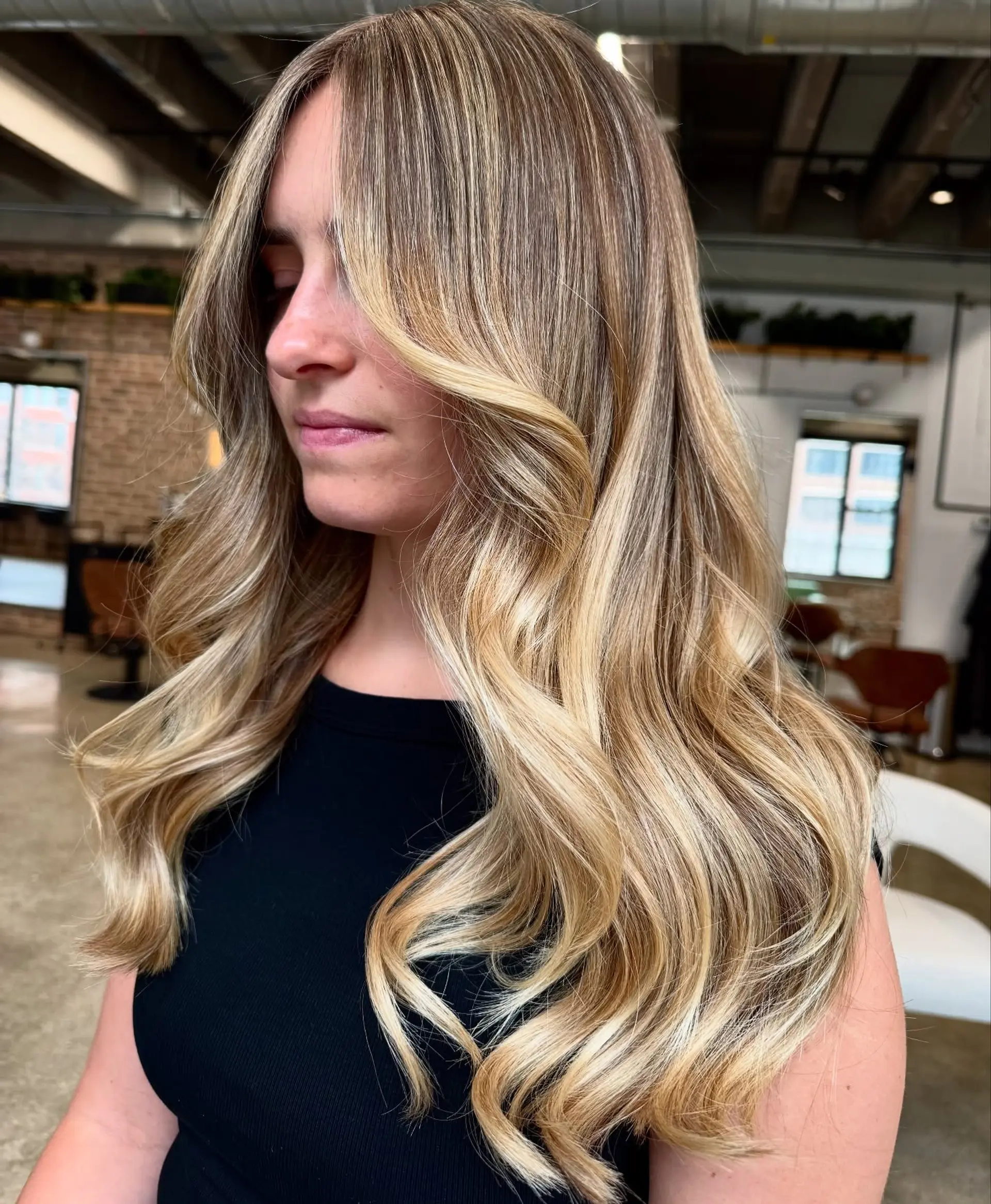 Long wavy hair with blonde balayage, face-framing layers, and beachy waves. 1