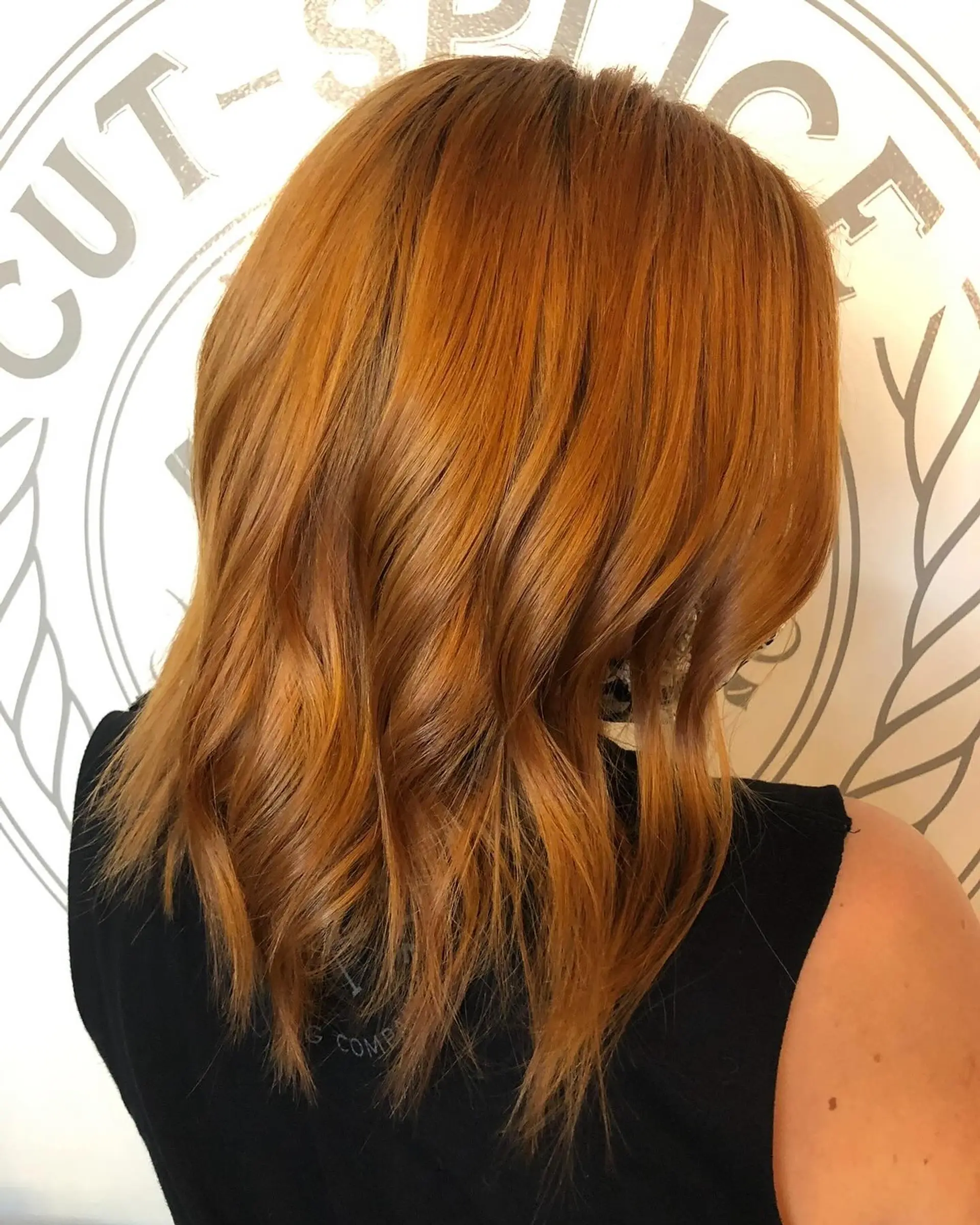 A rich warm copper medium-length bob styled with soft textured waves. 1
