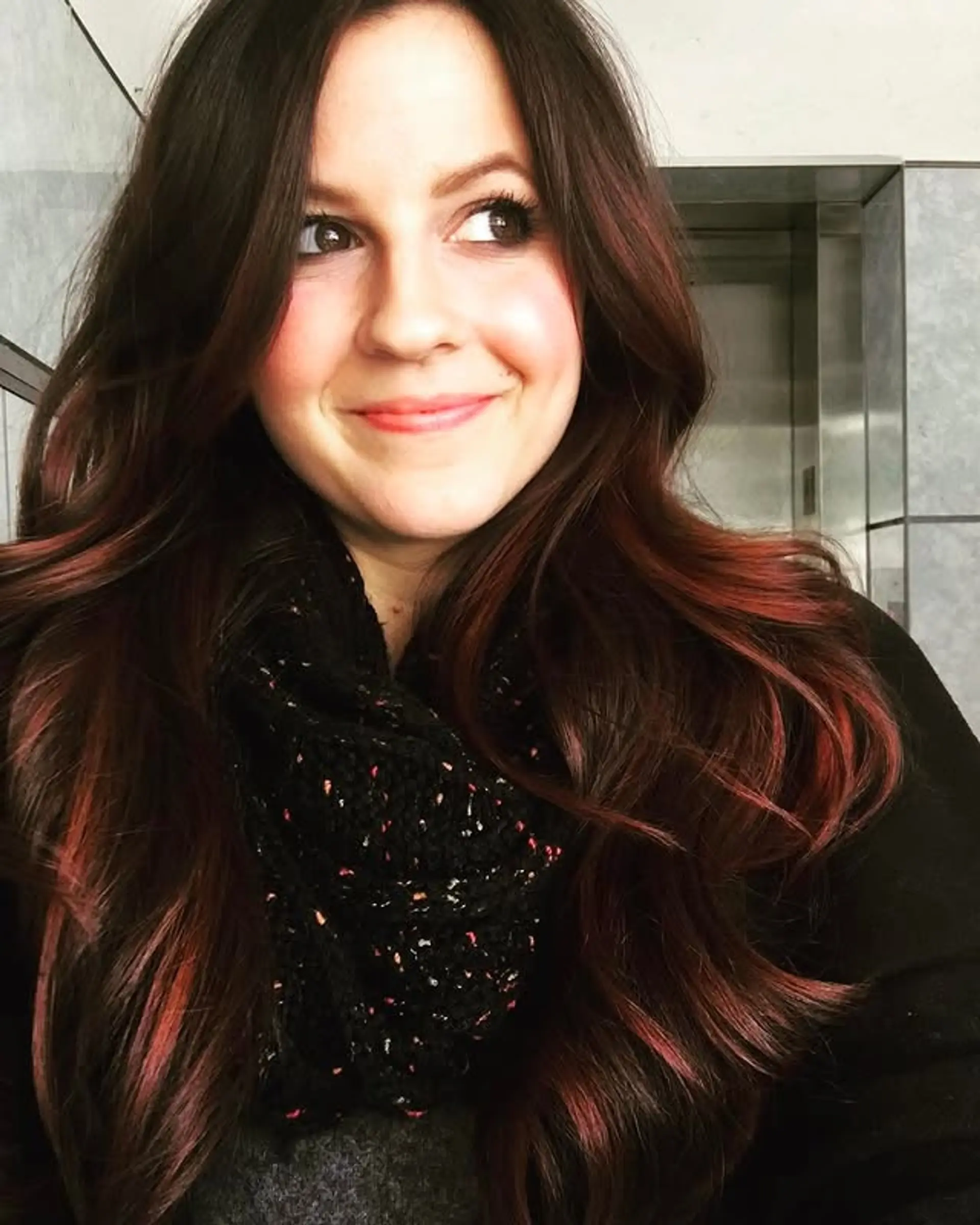 Long, wavy layered hair with an auburn and red ombre effect. 1