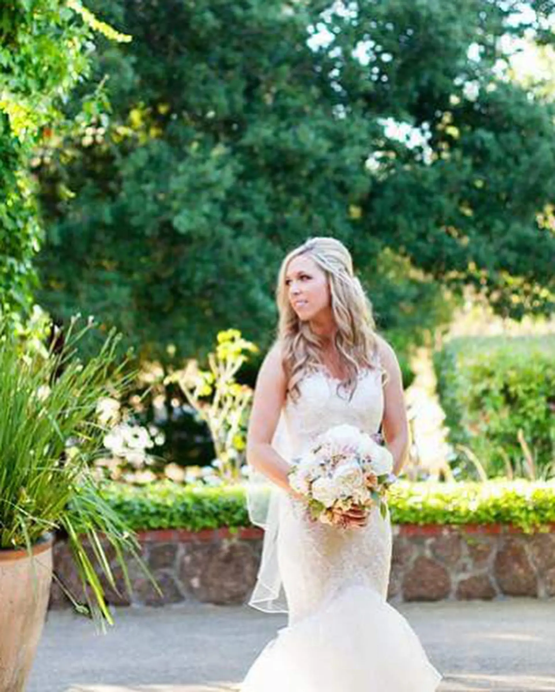 Long blonde hair styled in soft, flowing bridal waves draped over the shoulders. 1