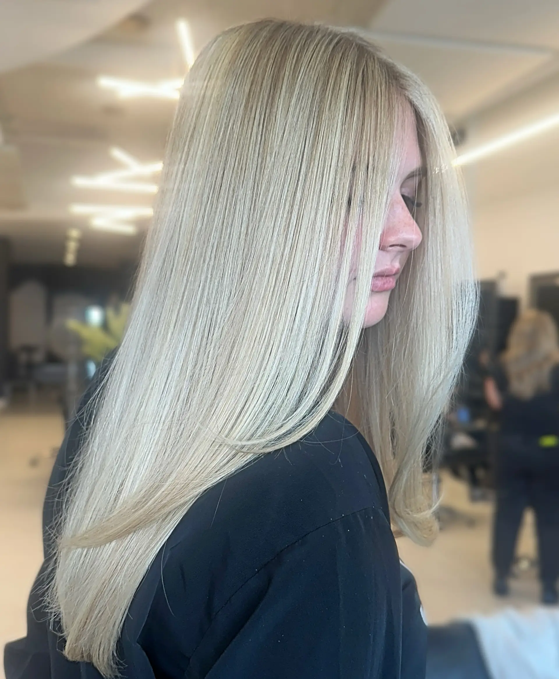 A sleek, smooth blowout on long, bright platinum blonde hair with soft face-framing layers. 1