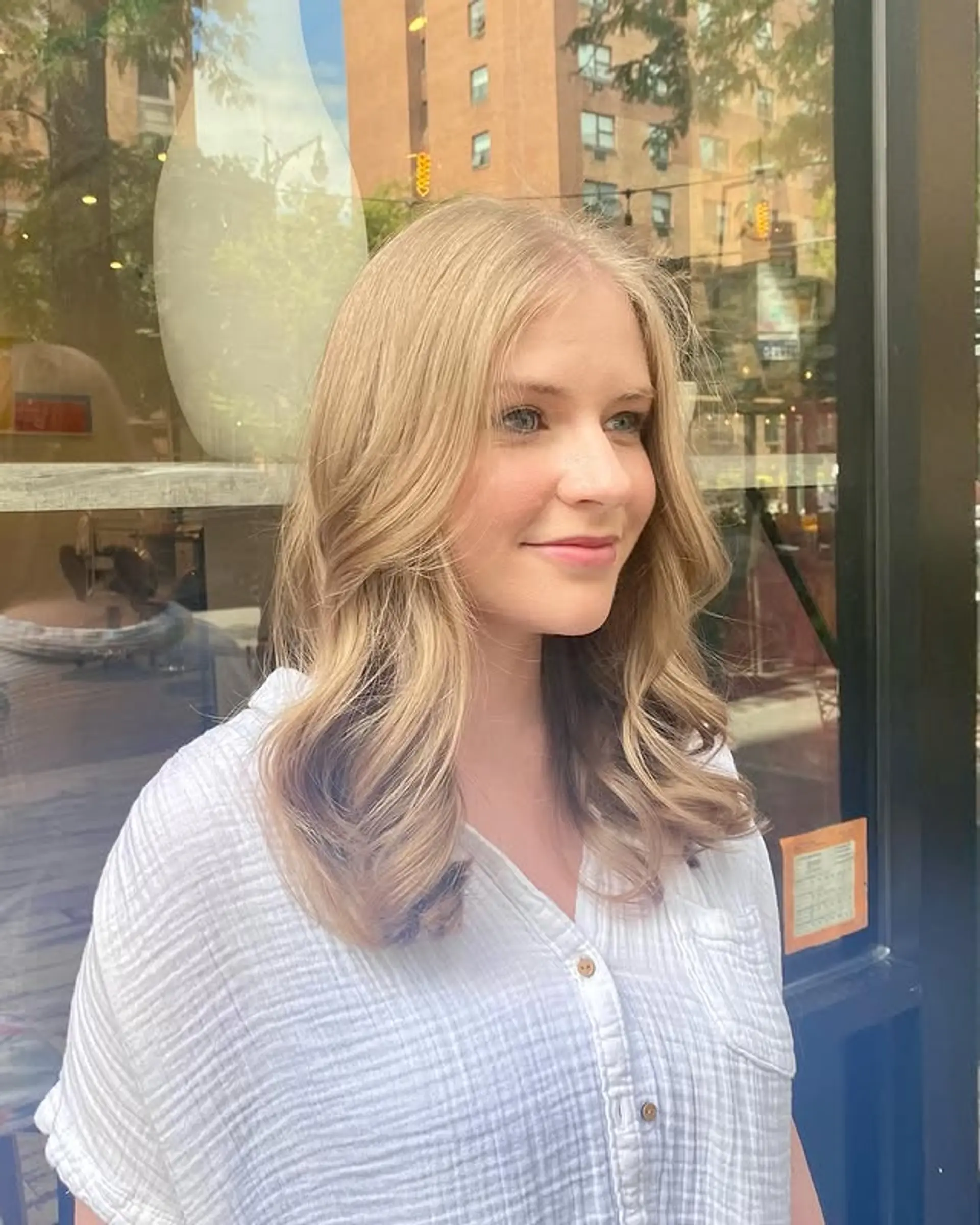 A medium-length wavy hairstyle with a blonde balayage and beachy waves. 1