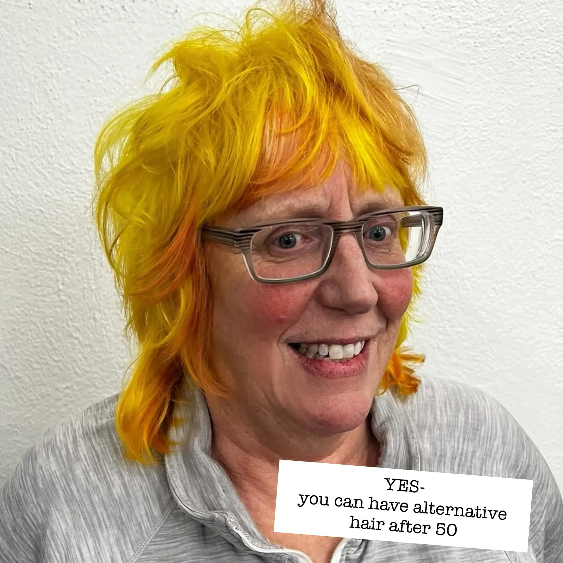 A textured shag haircut featuring vibrant neon yellow hair with subtle warm orange undertones and face-framing fringe. 1