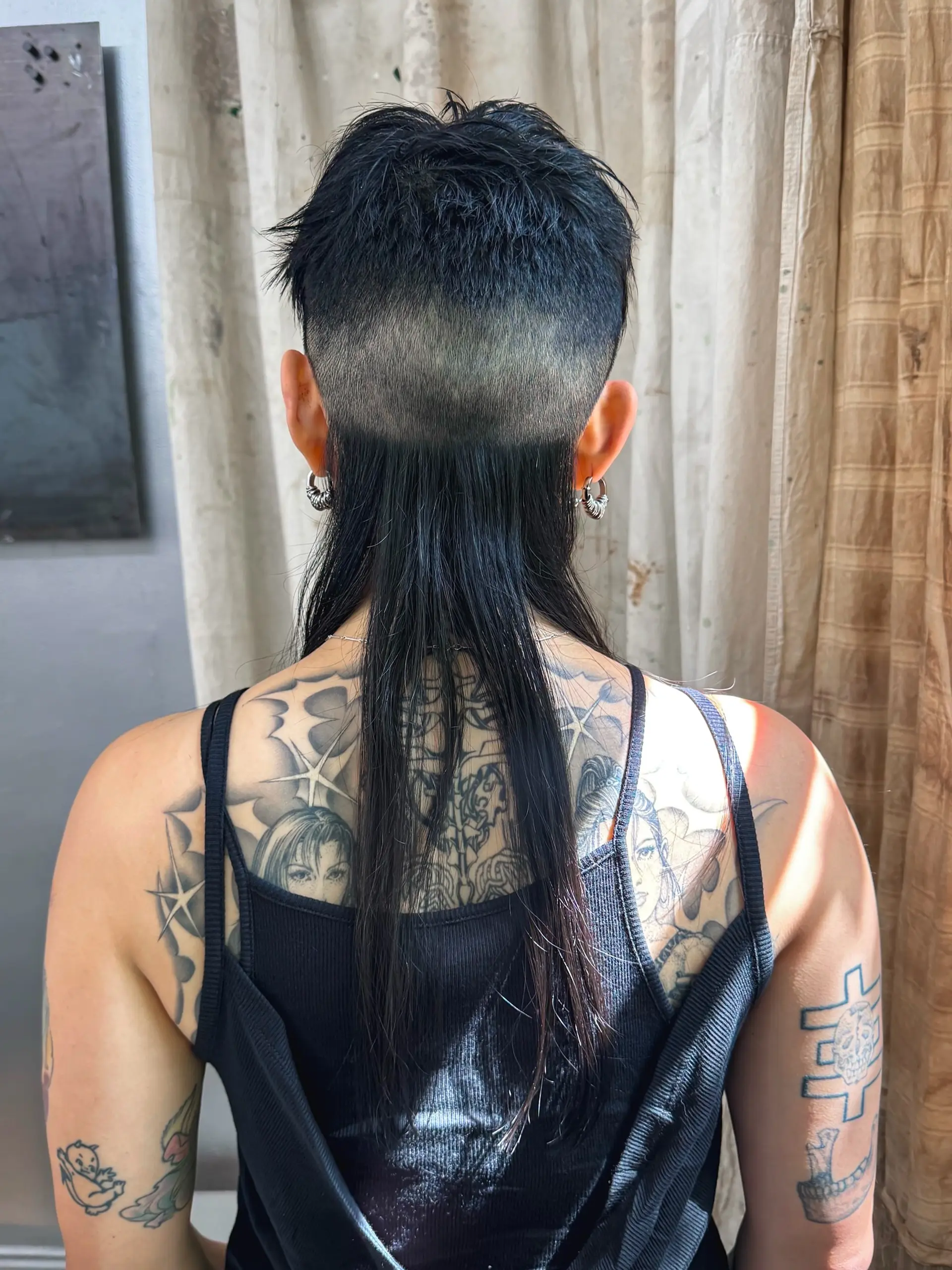 This modern mullet features a short, textured top with an undercut that fades into the longer back. 1