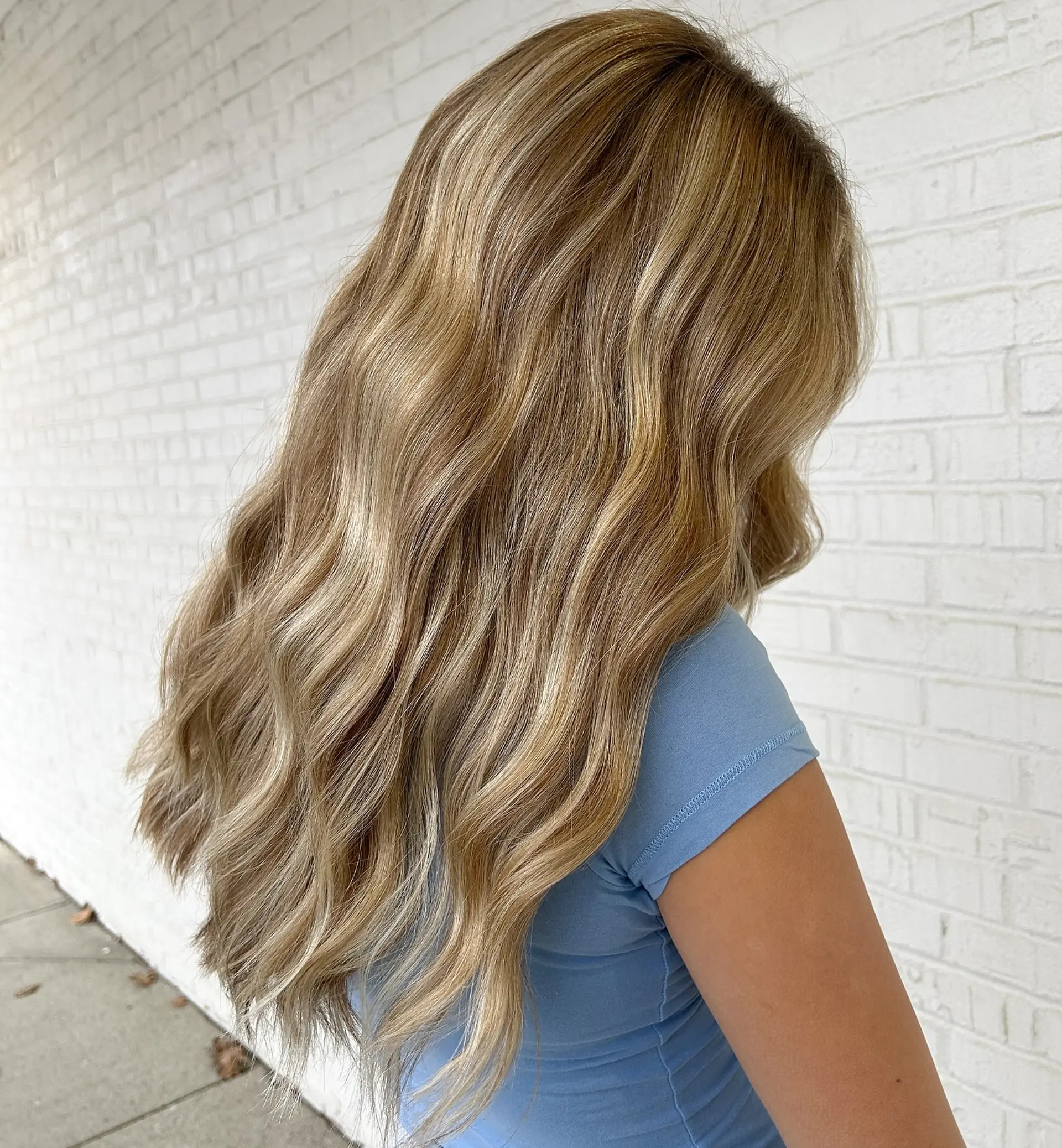 Long, dimensional warm blonde hair styled in soft, cascading waves. 1