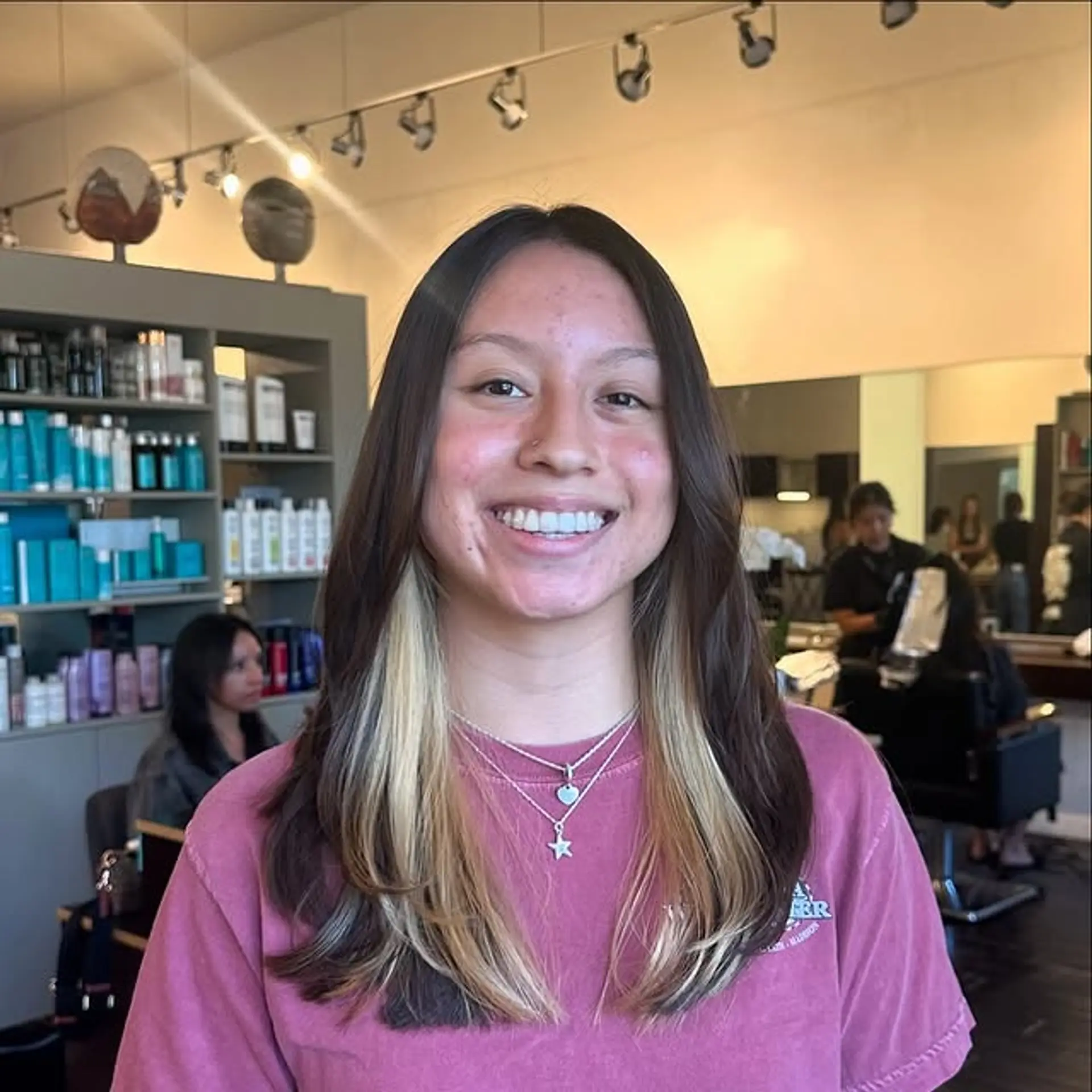 Medium length layered haircut with face-framing money piece highlights. 1