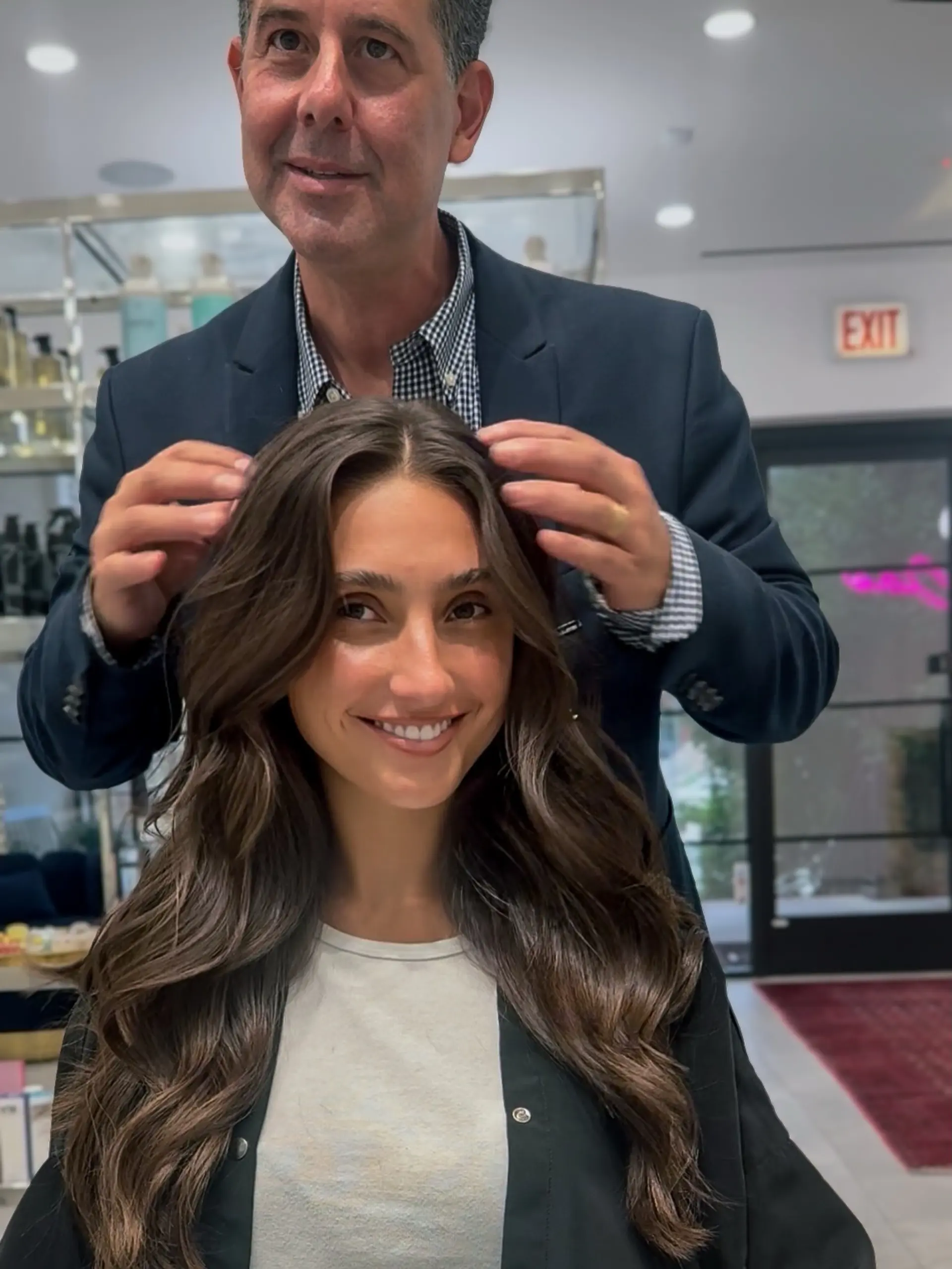 Long brunette hair cut with soft, face-framing layers and styled in flowing, voluminous waves with a center part. 1