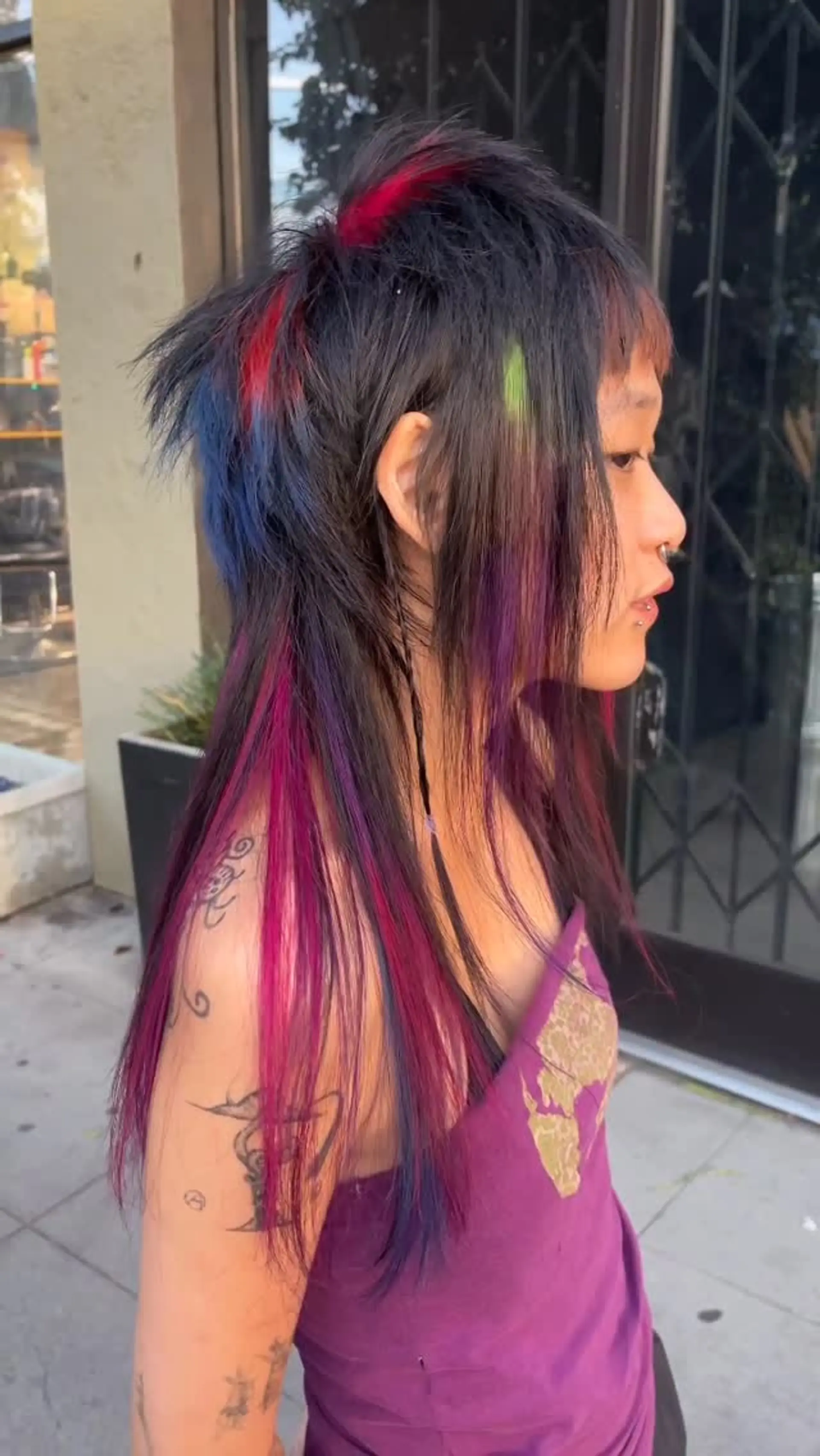 A heavily layered, choppy shag mullet on dark hair with bold vivid color chunks. 1