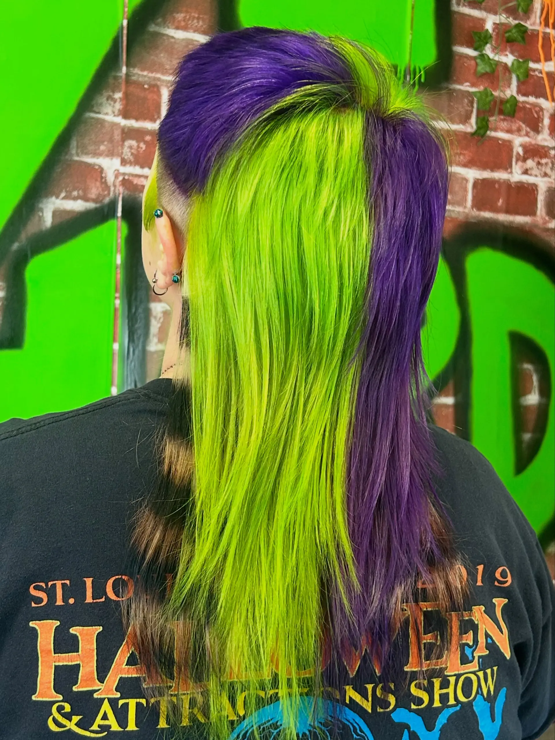An edgy alternative mullet featuring high-contrast panels of neon lime green and vivid purple with subtle raccoon tail banding. 1