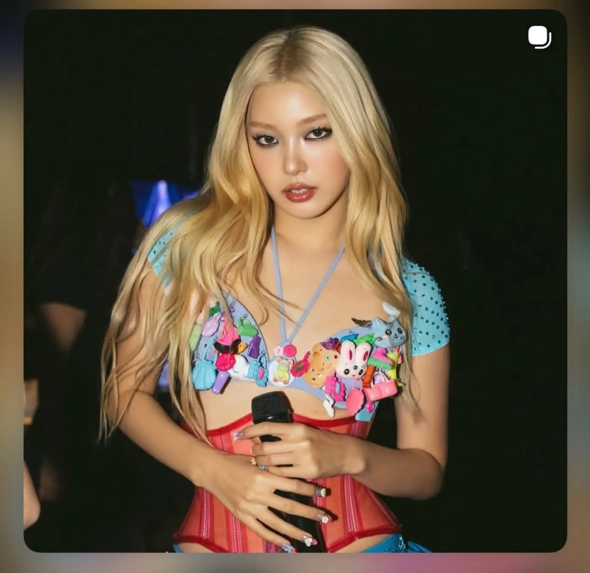 Long bright blonde hair styled with a center part and subtle loose waves. 1