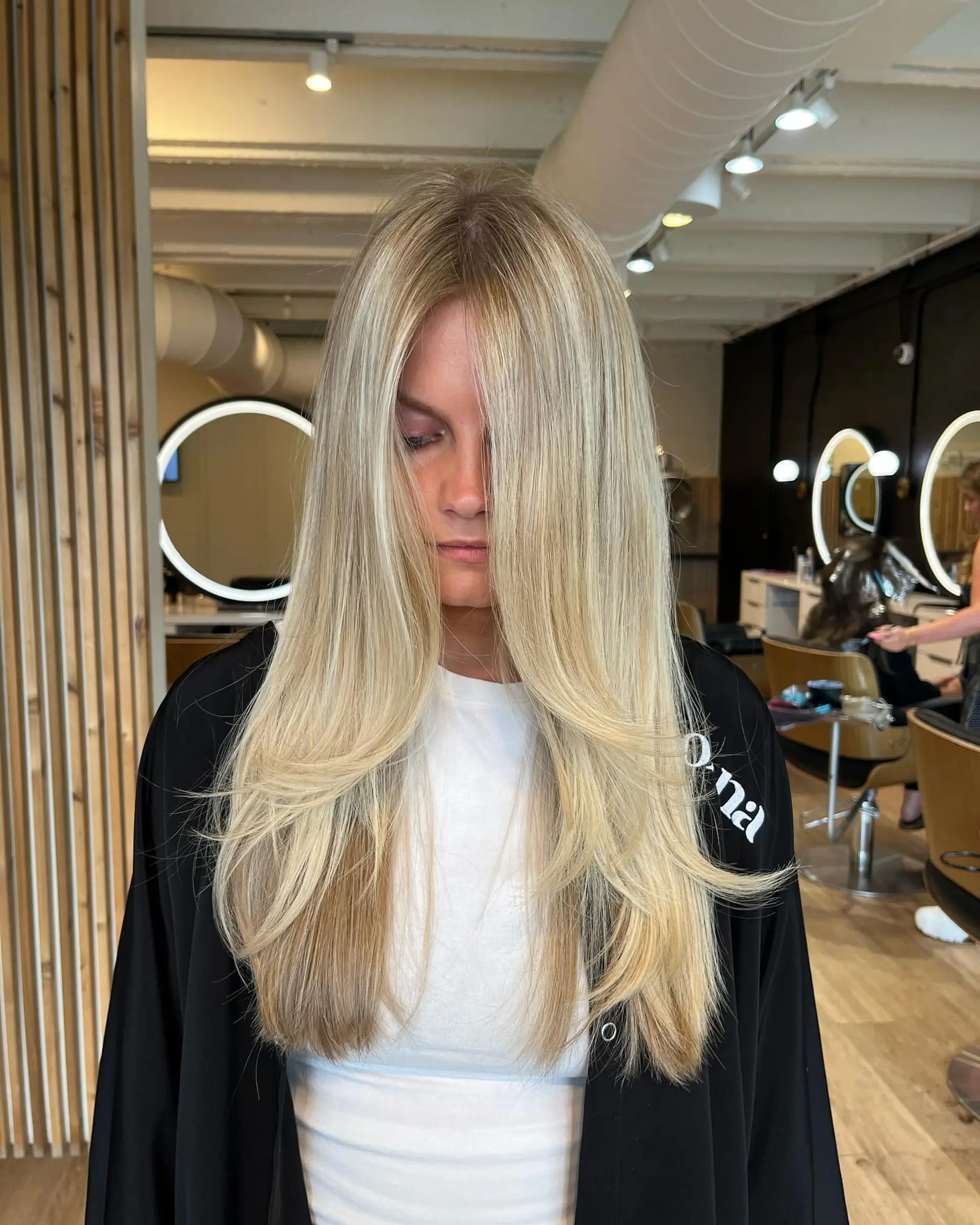 Long, smooth blonde hair styled with cascading face-framing layers and soft, natural movement. 1