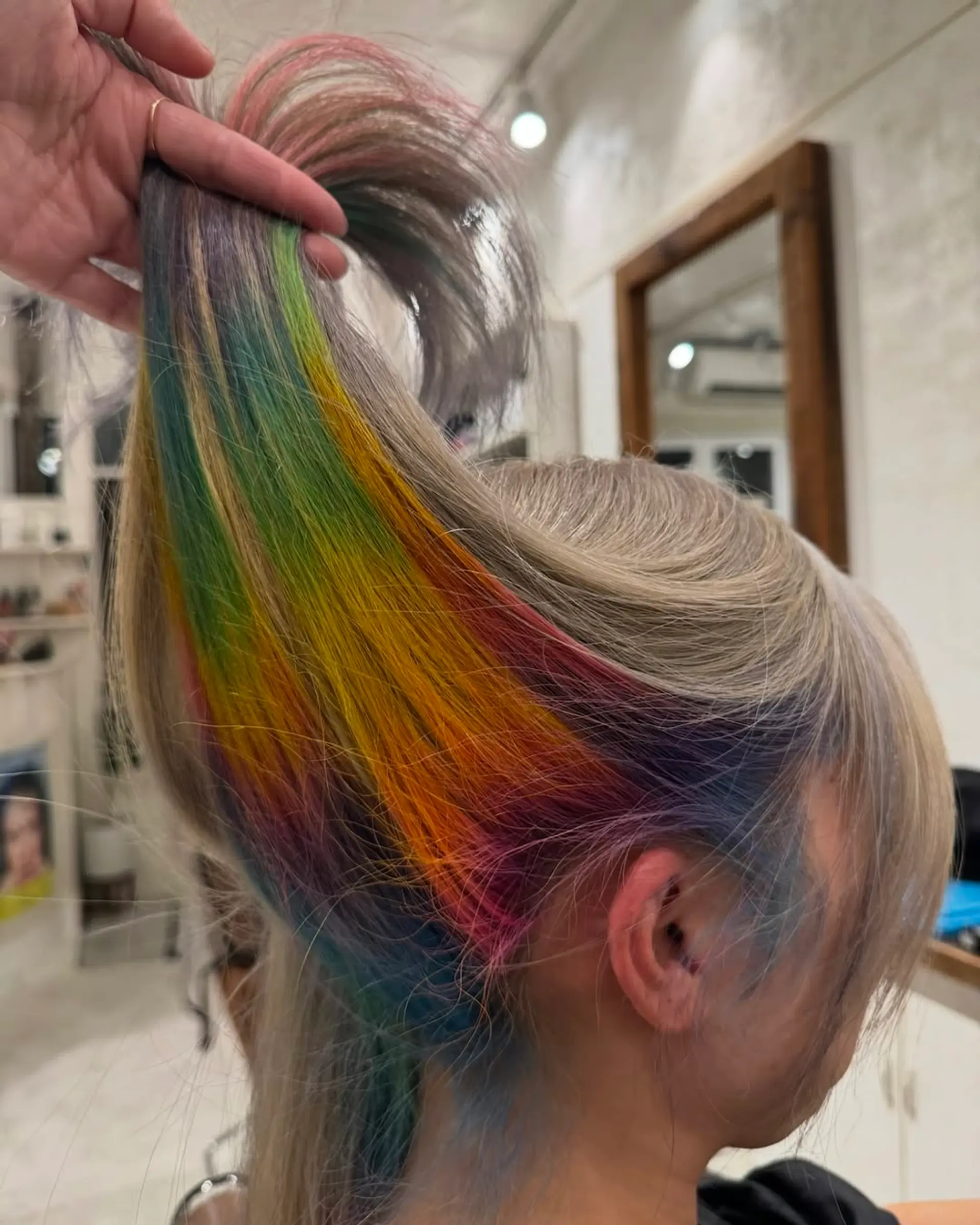 A long, straight hairstyle featuring a vibrant, multicolored gradient with bold highlights in yellow, green, blue, purple, orange, and red. 2