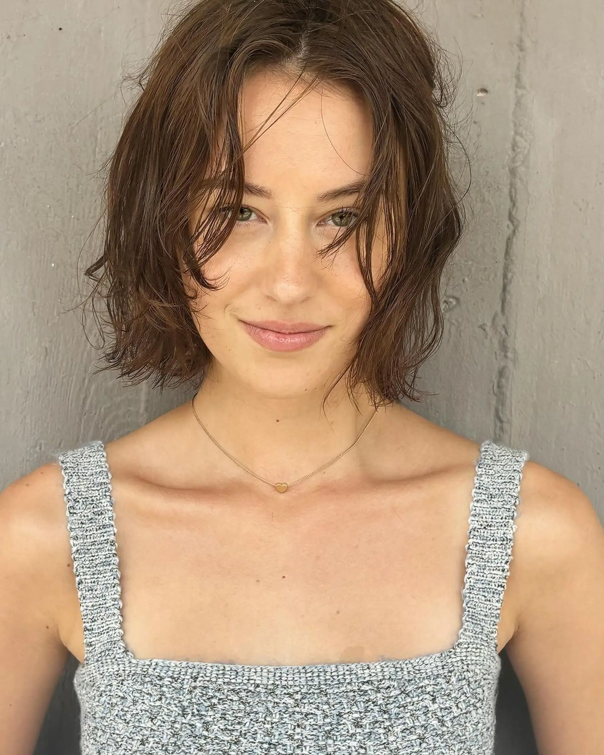 Short, wavy bob cut with a tousled, casual style and medium brown color. 1