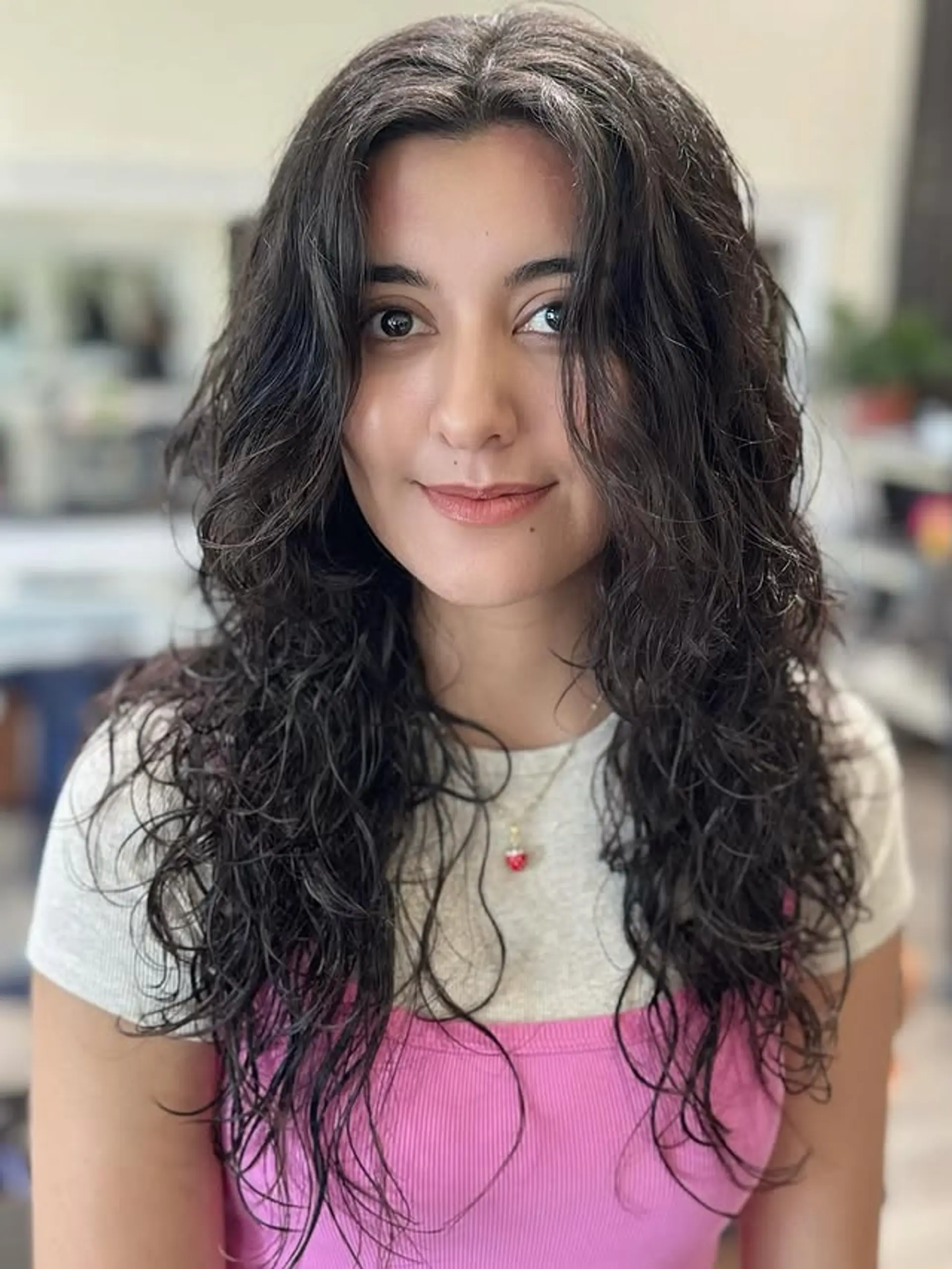 A long, wavy hairstyle characterized by soft, face-framing layers and a relaxed center part, enhancing natural texture and volume. 1