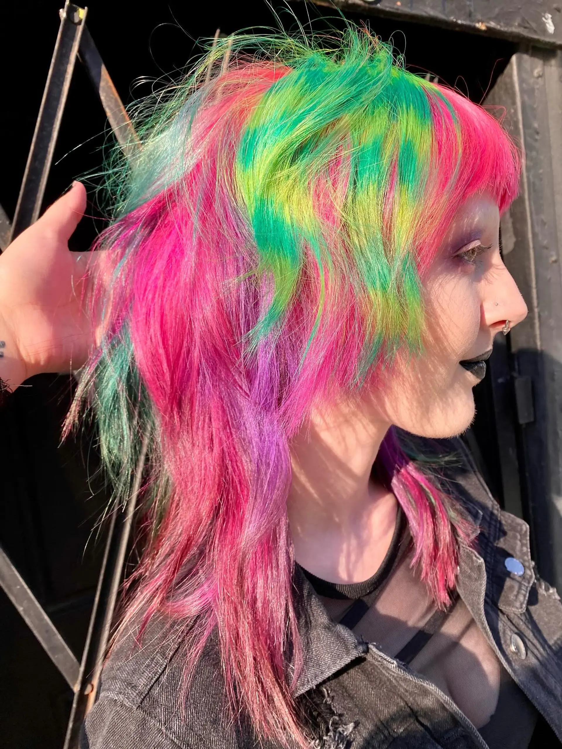A vibrant medium-length layered mullet in a neon rainbow palette. 1