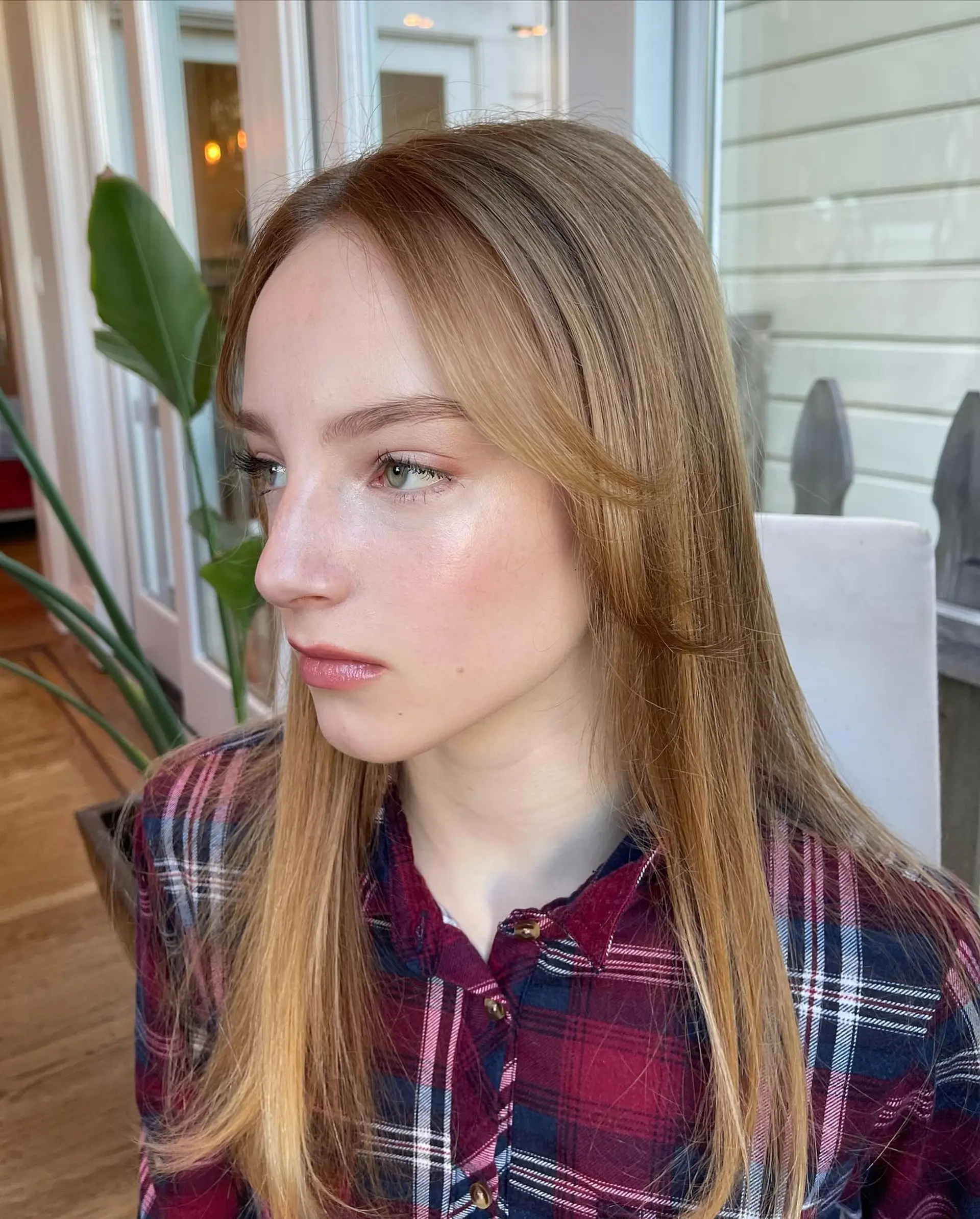 A sleek, smooth blowout featuring soft face-framing layers and parted fringe on long, warm golden hair. 1