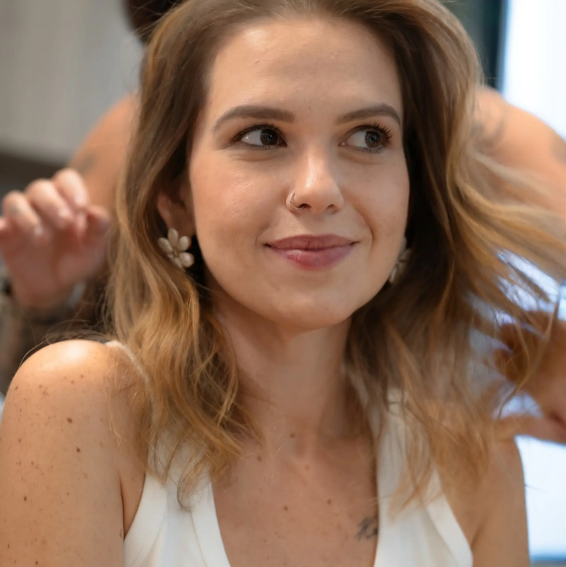 Medium-length light brown hair with soft warm blonde highlights, styled in voluminous, airy waves. 1