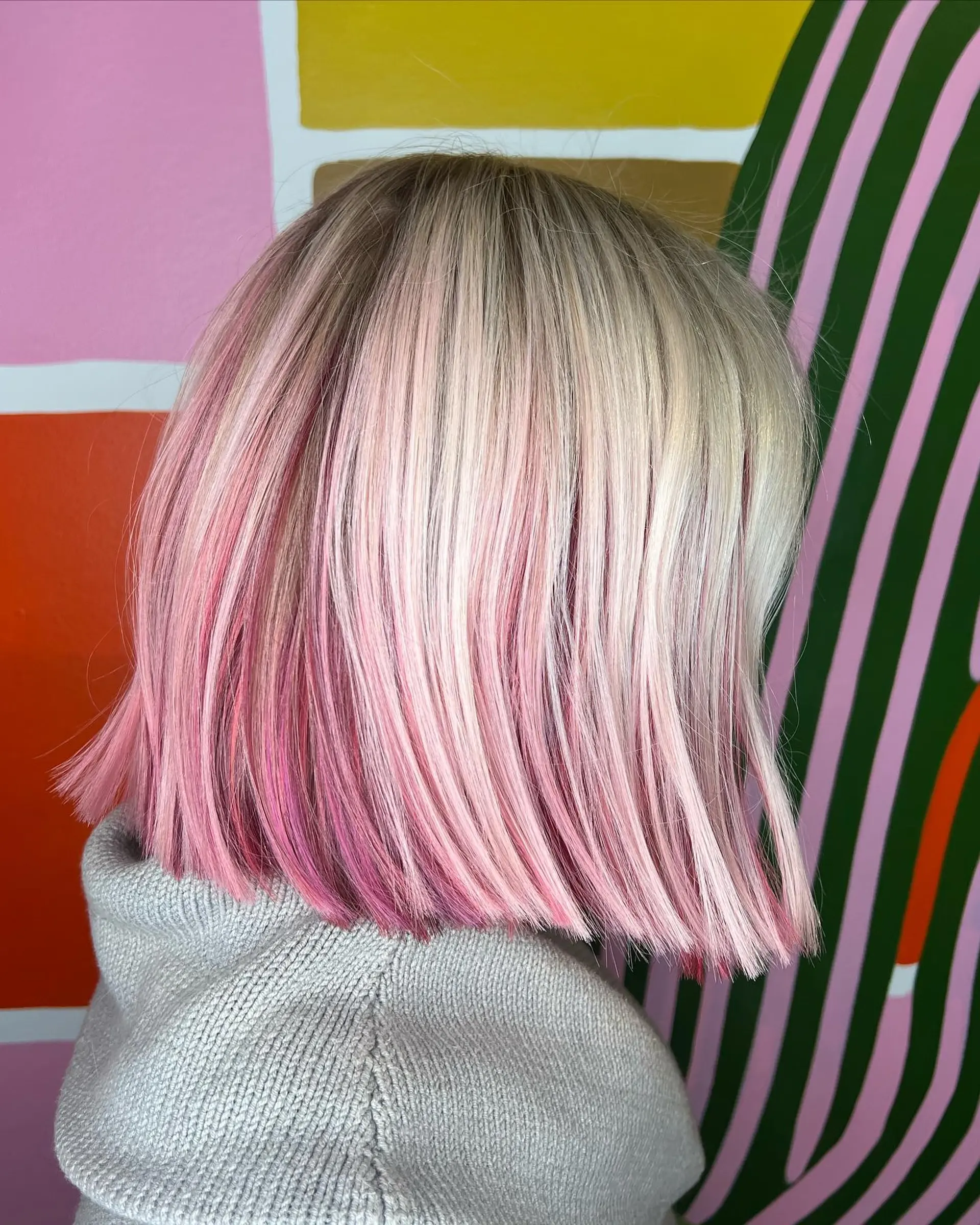 A sleek, blunt bob featuring a platinum blonde base interwoven with dimensional pastel and magenta pink highlights. 1