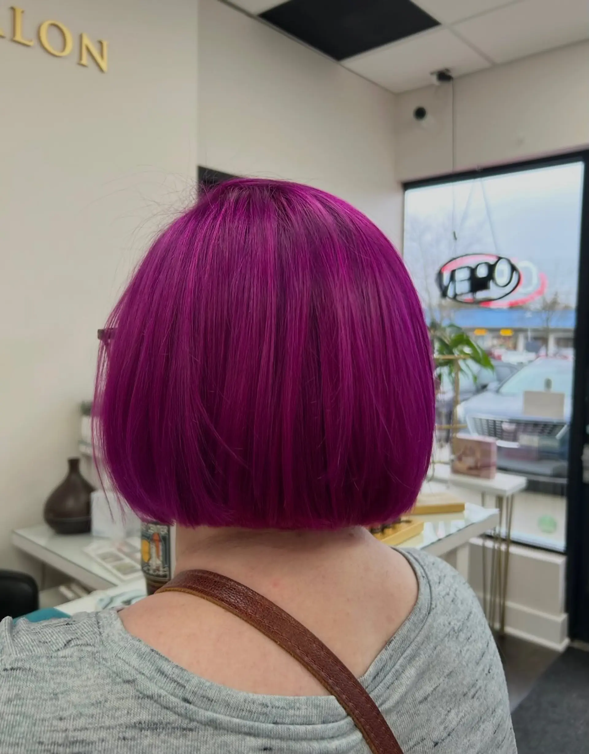 A sleek, straight blunt bob dyed in a vivid magenta and violet tone. 1