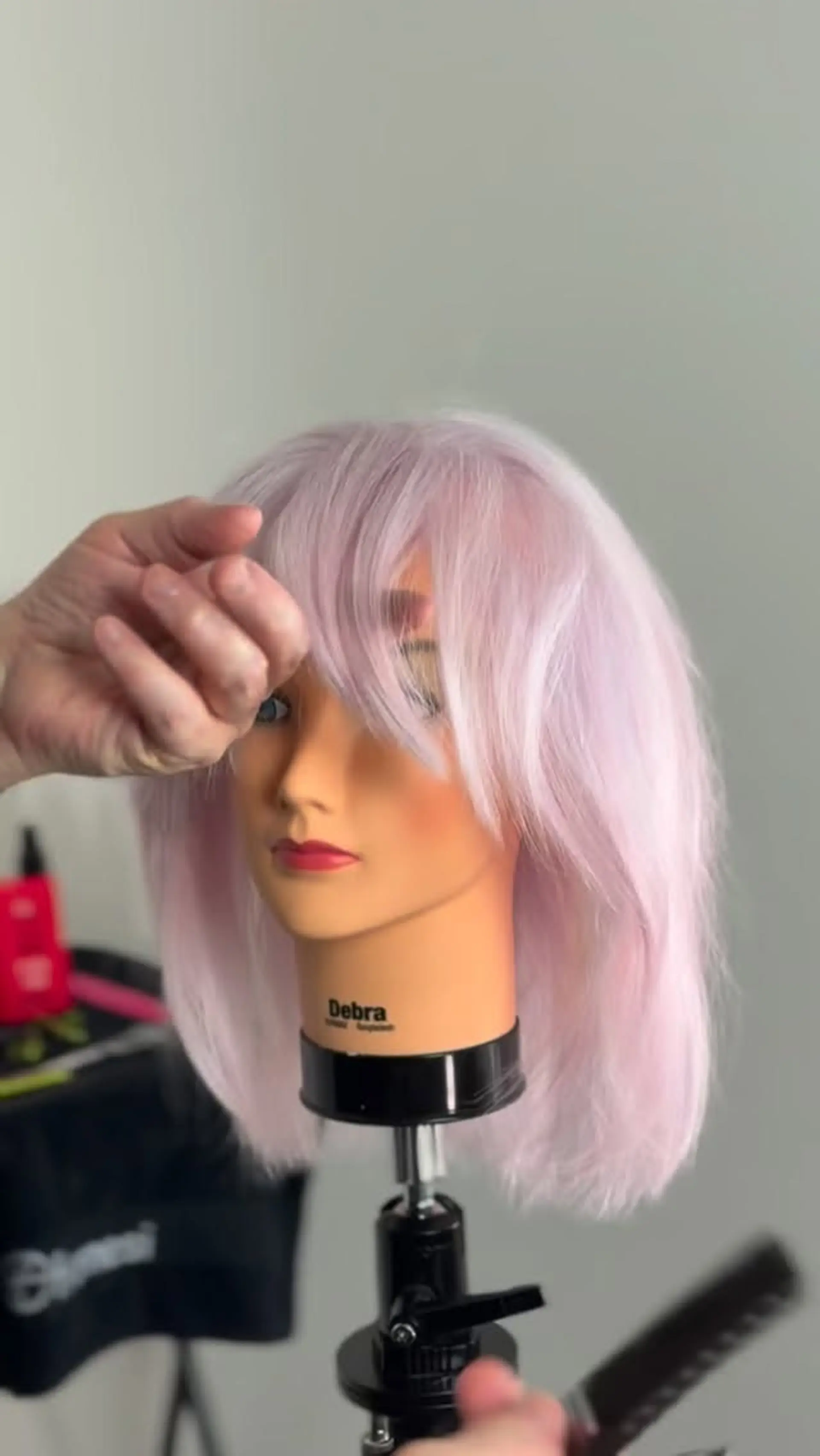 A medium-length textured lob in a soft pastel lavender tone, styled with a layered, face-framing fringe. 1