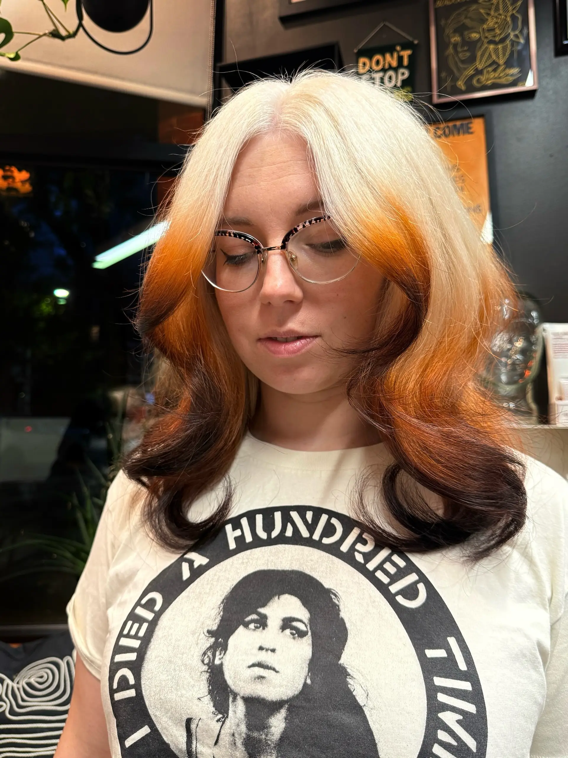 A mid-length blowout showcasing a high-contrast tri-tone color design with flipped ends and face-framing layers. 1