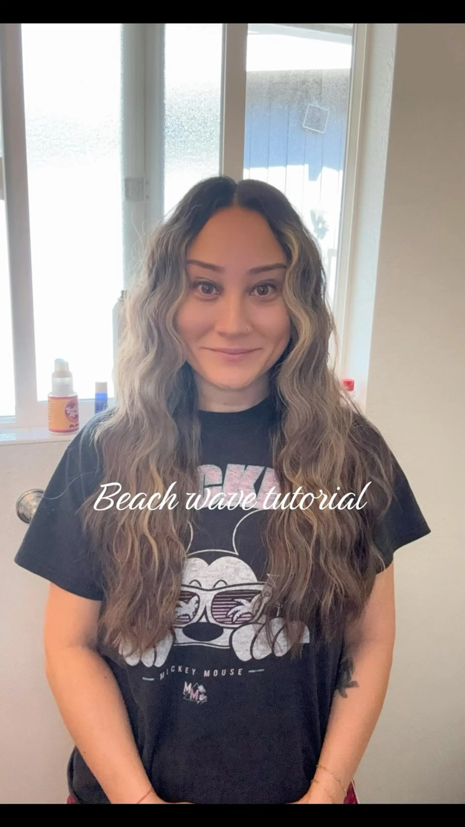 Long hair styled in textured beach waves featuring dark brown roots and blonde face-framing highlights. 1