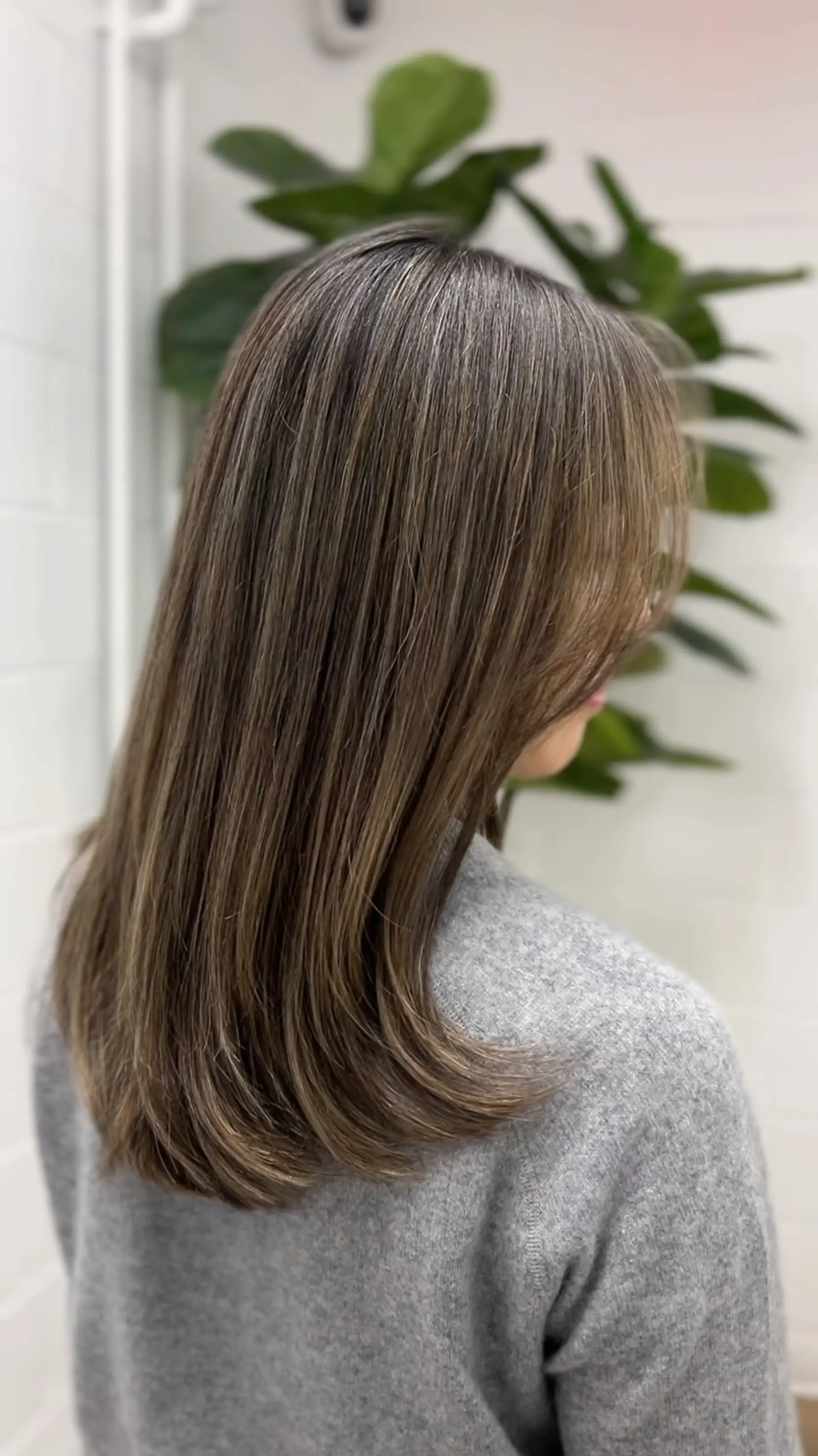 Medium-length straight hair styled with softly curved ends, featuring seamless lived-in dimensional balayage highlights over an ash brown base. 1