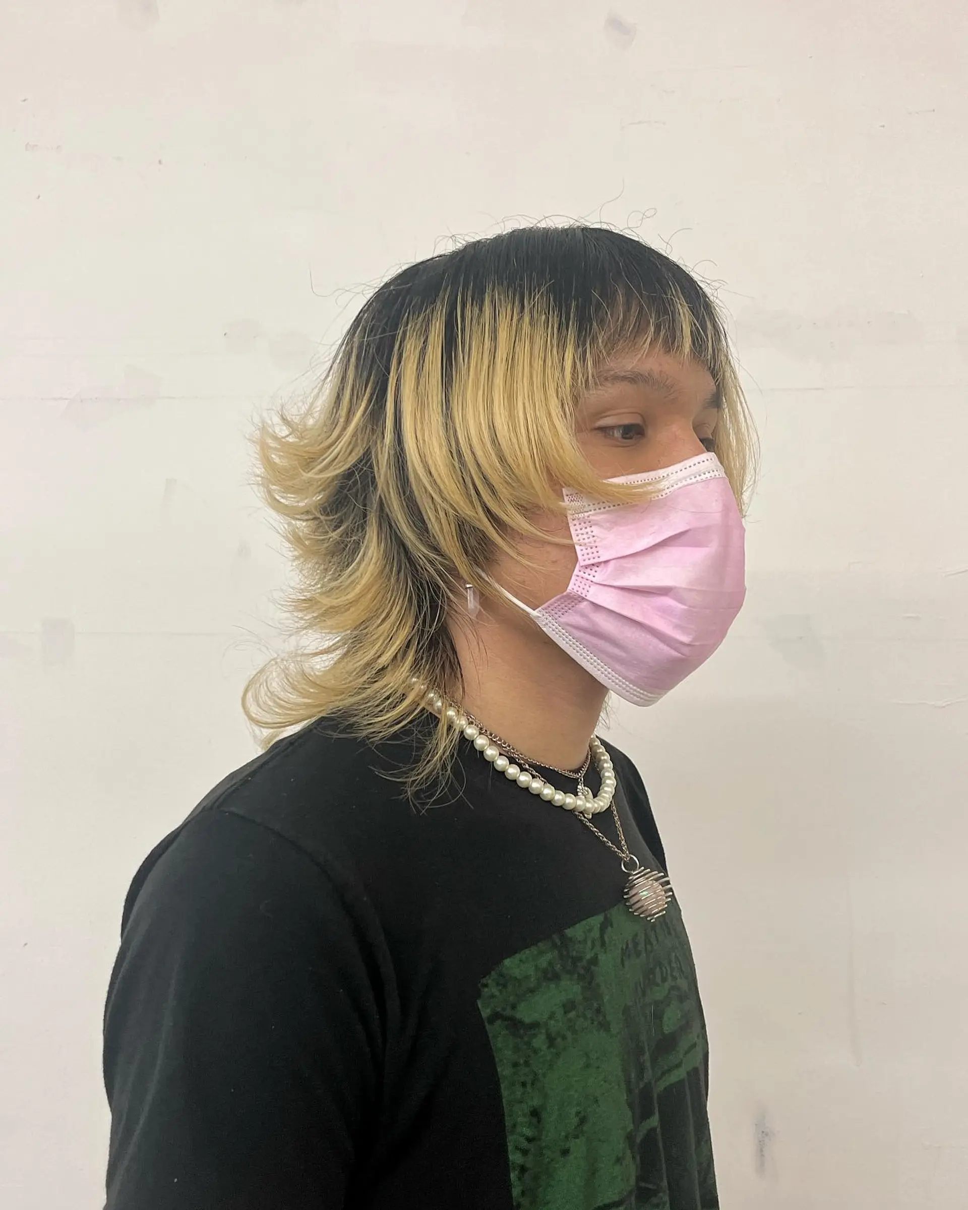A layered, textured wolf cut featuring flipped ends, short textured fringe, and high-contrast dark roots blending into blonde lengths. 1