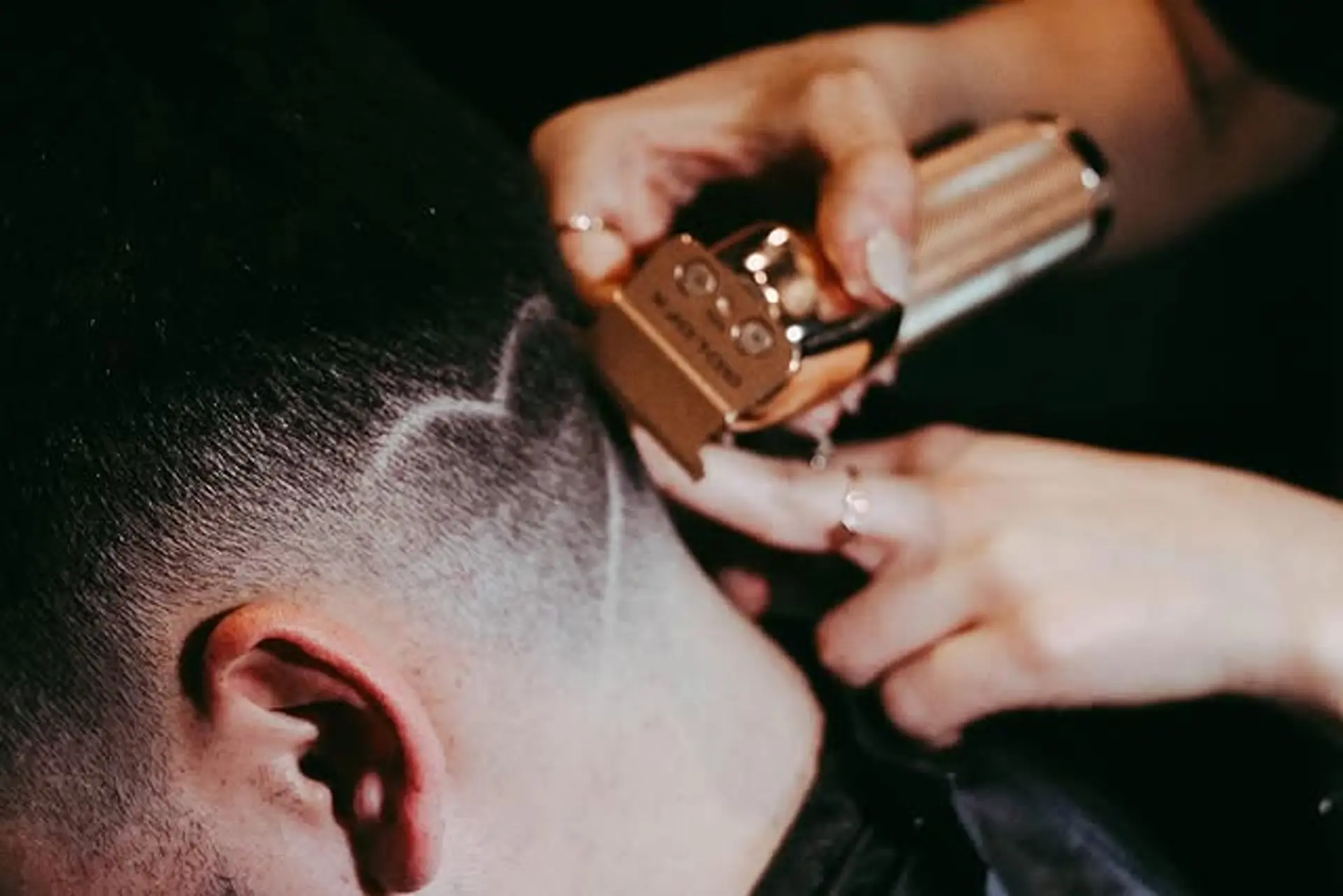 A short fade haircut with a distinctive hair tattoo design shaved into the side. 1