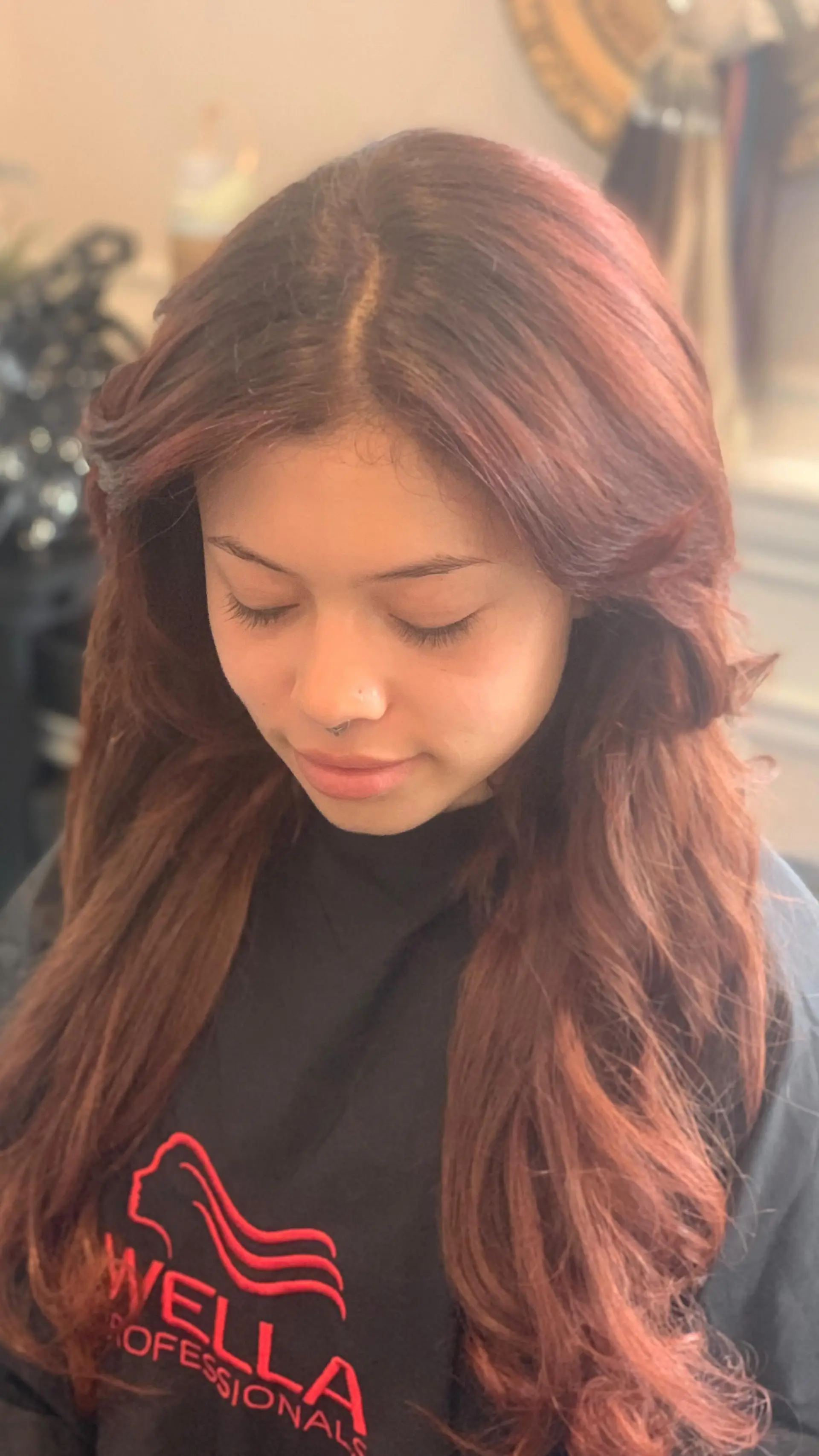 Long auburn hair styled into a soft, voluminous blowout with feathered, face-framing layers. 1