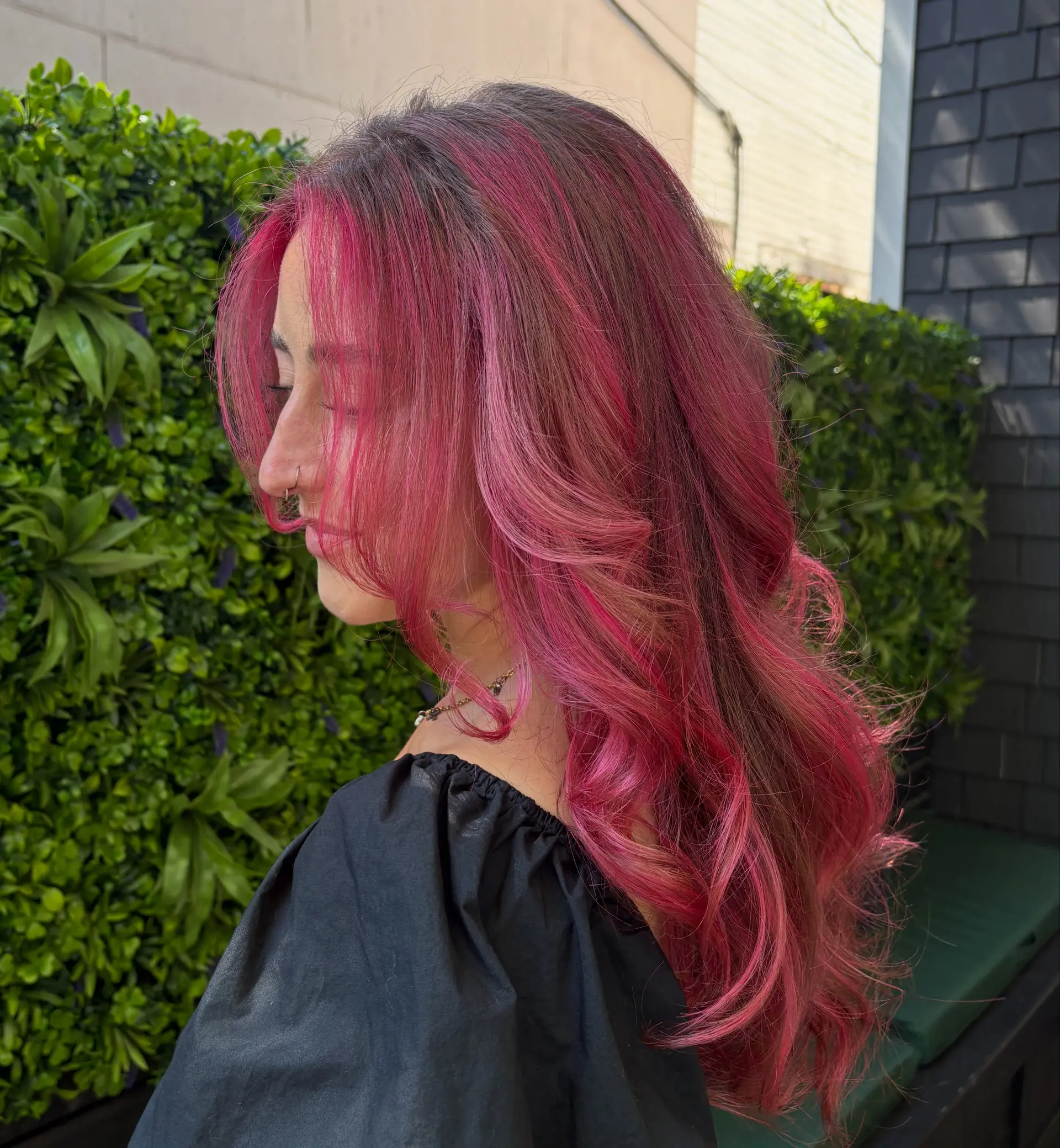 Long layered hair styled with soft, voluminous curls, featuring vibrant hot pink and magenta tones with subtle dark root dimension. 1