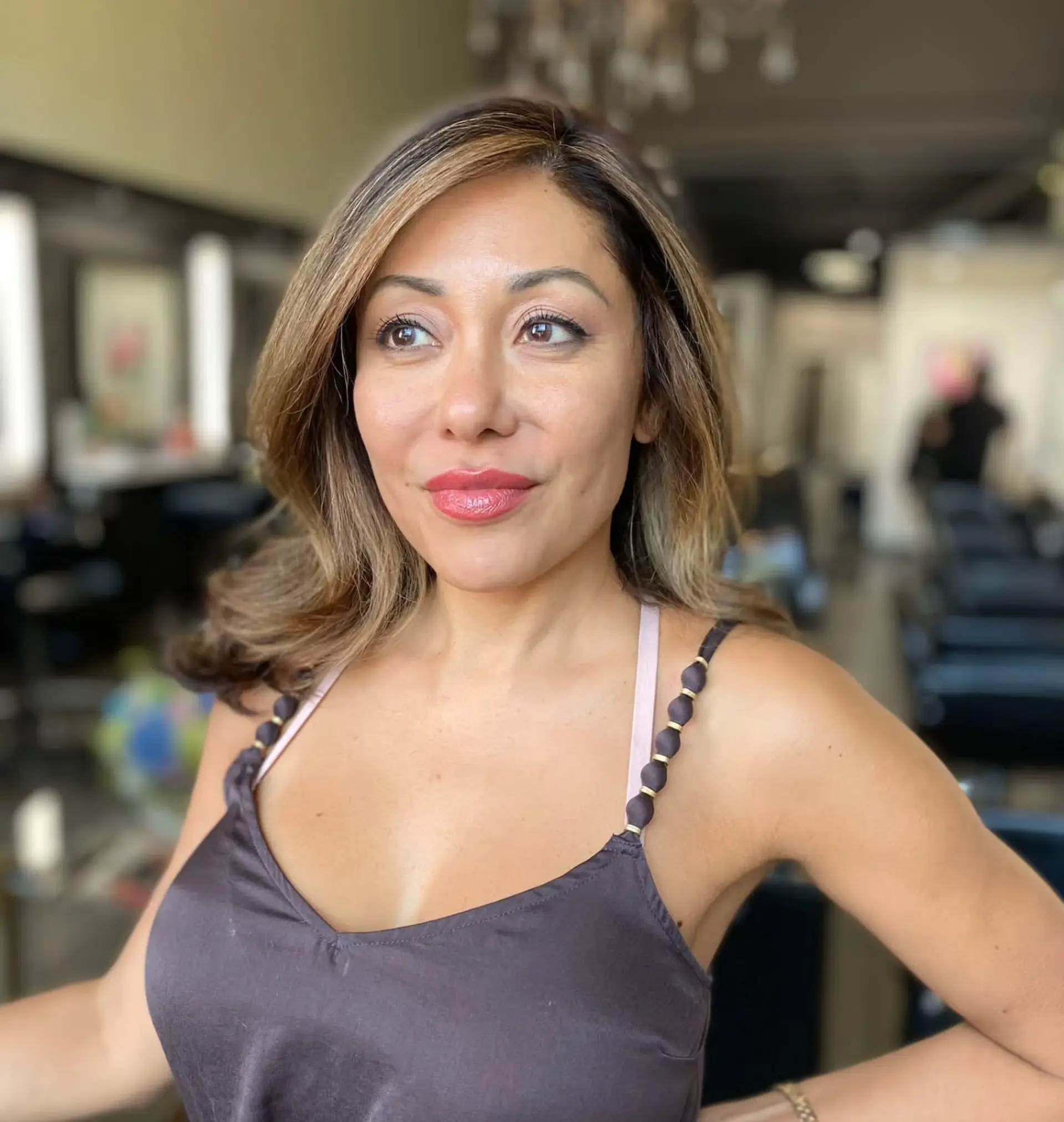 Medium-length layered hair styled in a voluminous blowout with face-framing honey blonde ribbons over a brunette base. 1