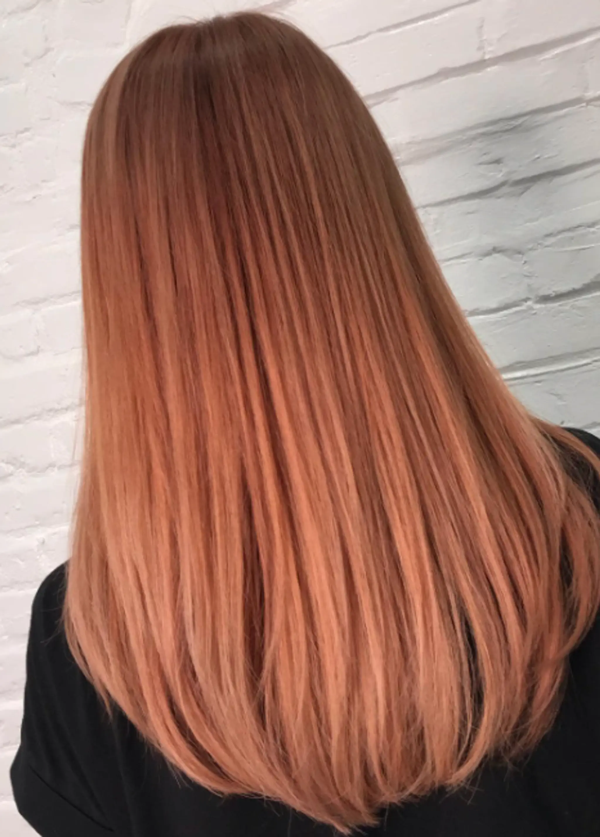 Long, straight hair with a silky, smooth texture, featuring light auburn and copper tones for a vibrant, gleaming appearance.