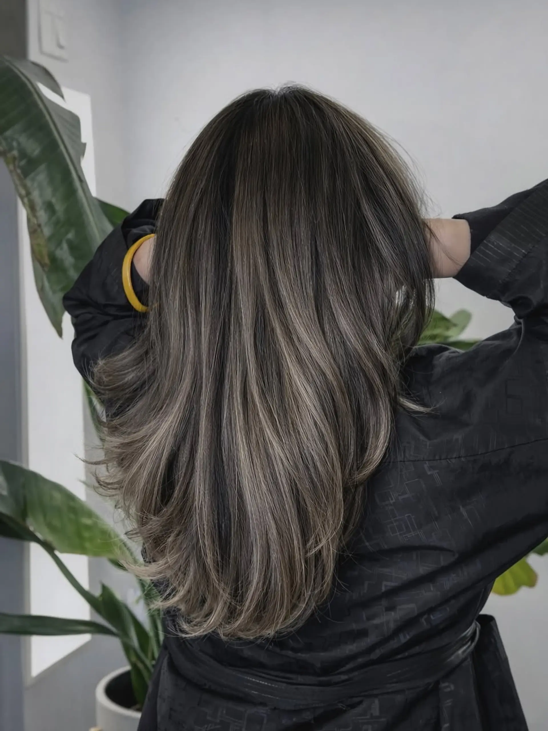 Long, straight hair with subtle layering at the ends, featuring a dimensional balayage technique with cool ash-toned highlights. 1