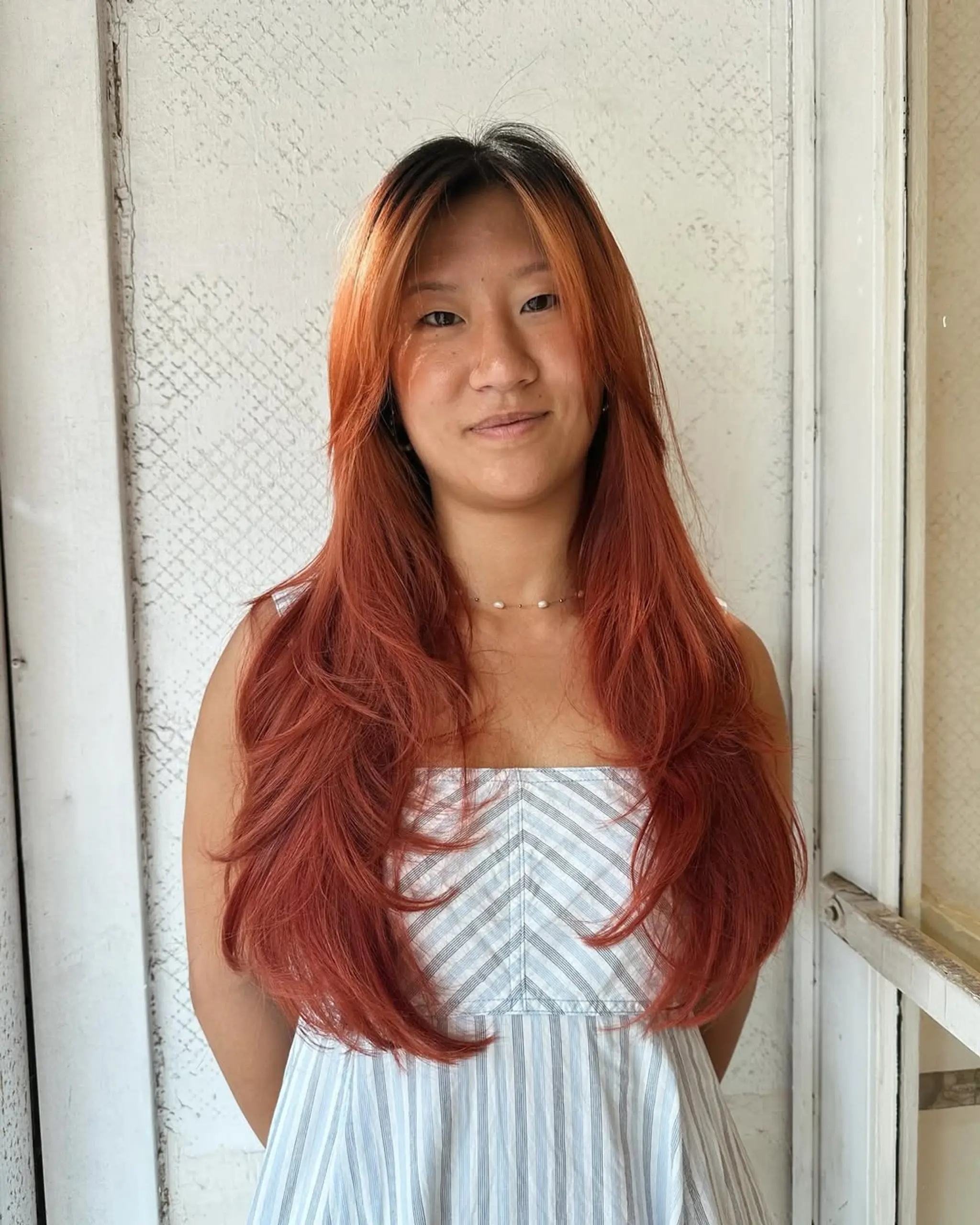 Long, wavy crimson hair with layered cut and dual-tone coloring, featuring long bangs and voluminous styling.