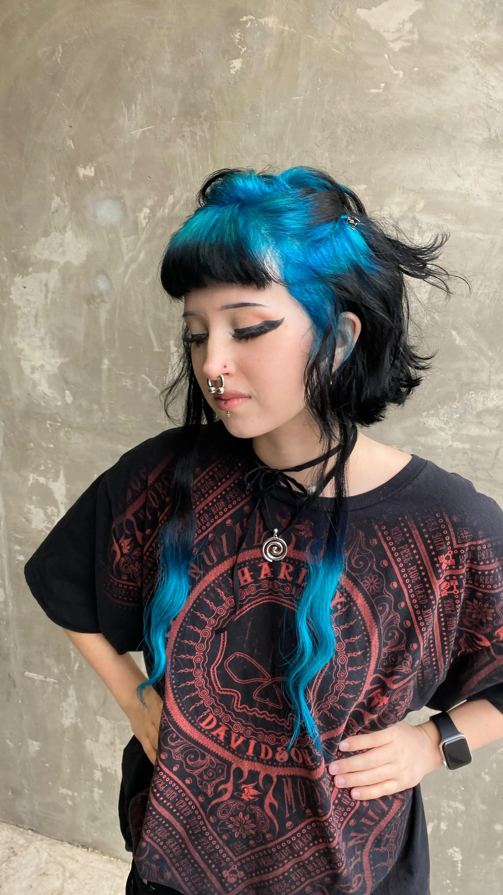 Alternative cut featuring short textured black layers and blunt micro-bangs paired with vibrant electric blue crown panels and long front tendrils. 1