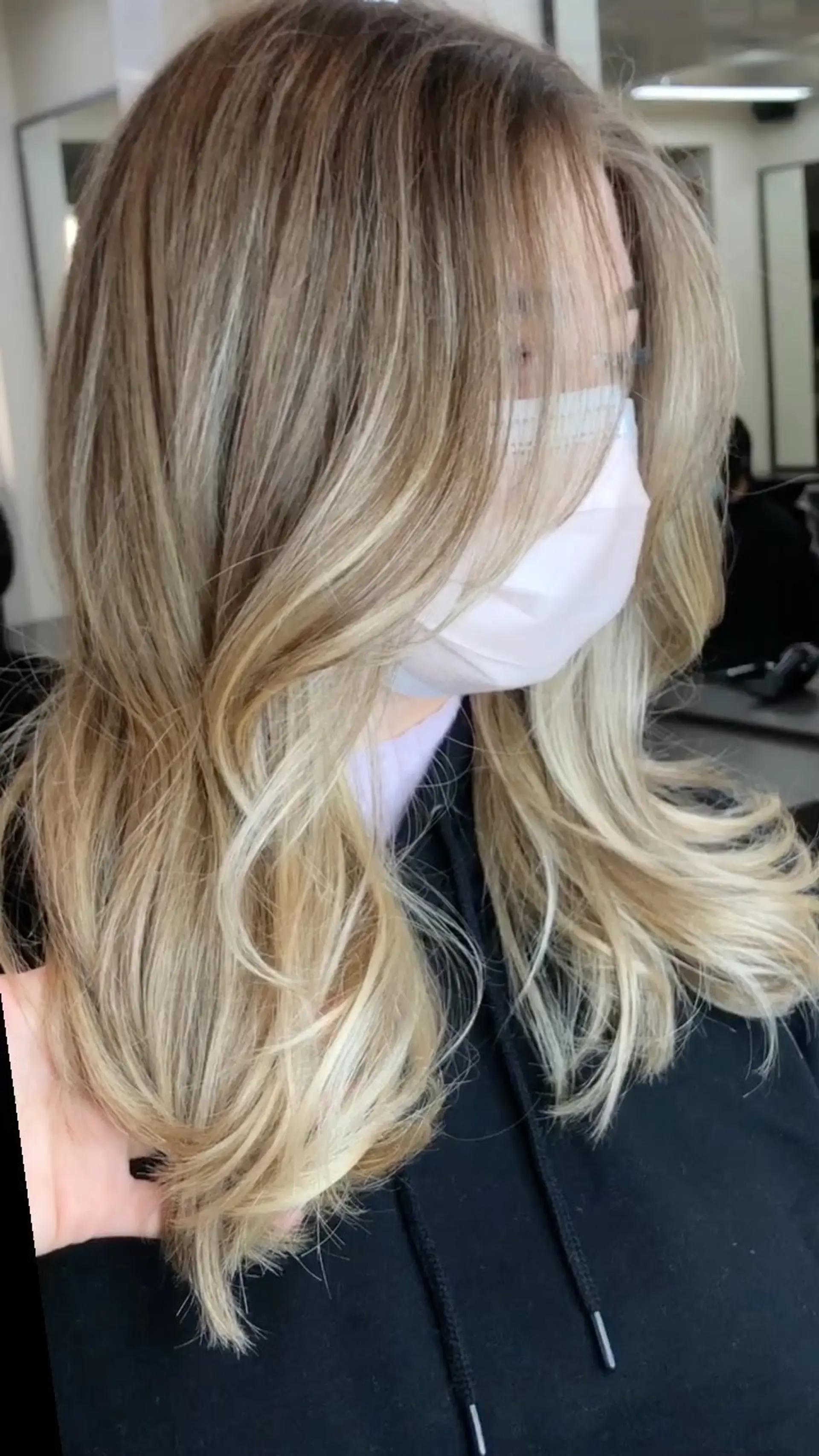 A warm-toned dimensional bronde color melt styled into soft, layered blowout waves. 1
