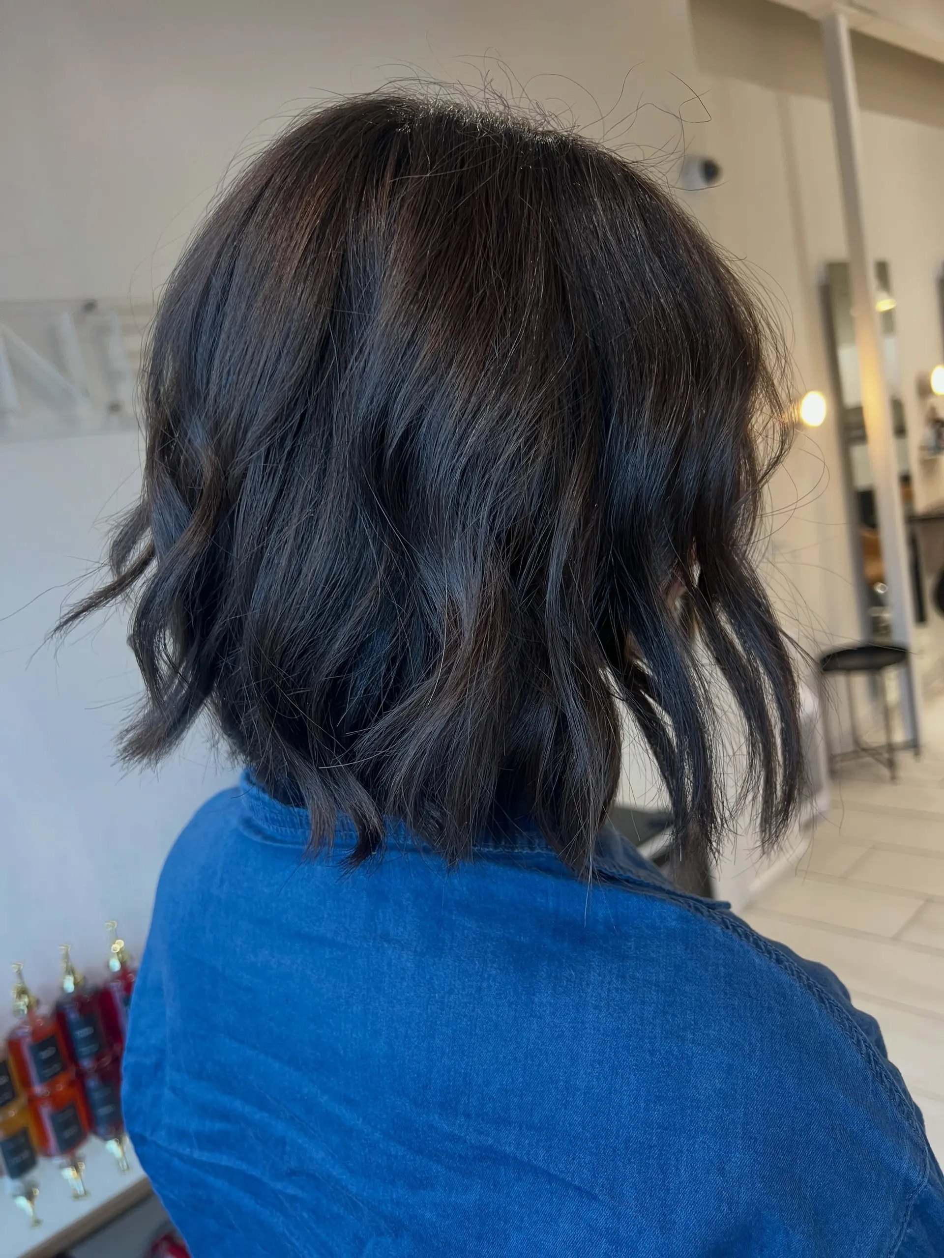 A short, neck-length textured bob styled with loose, piecey waves and subtle, natural dimensional highlights. 1