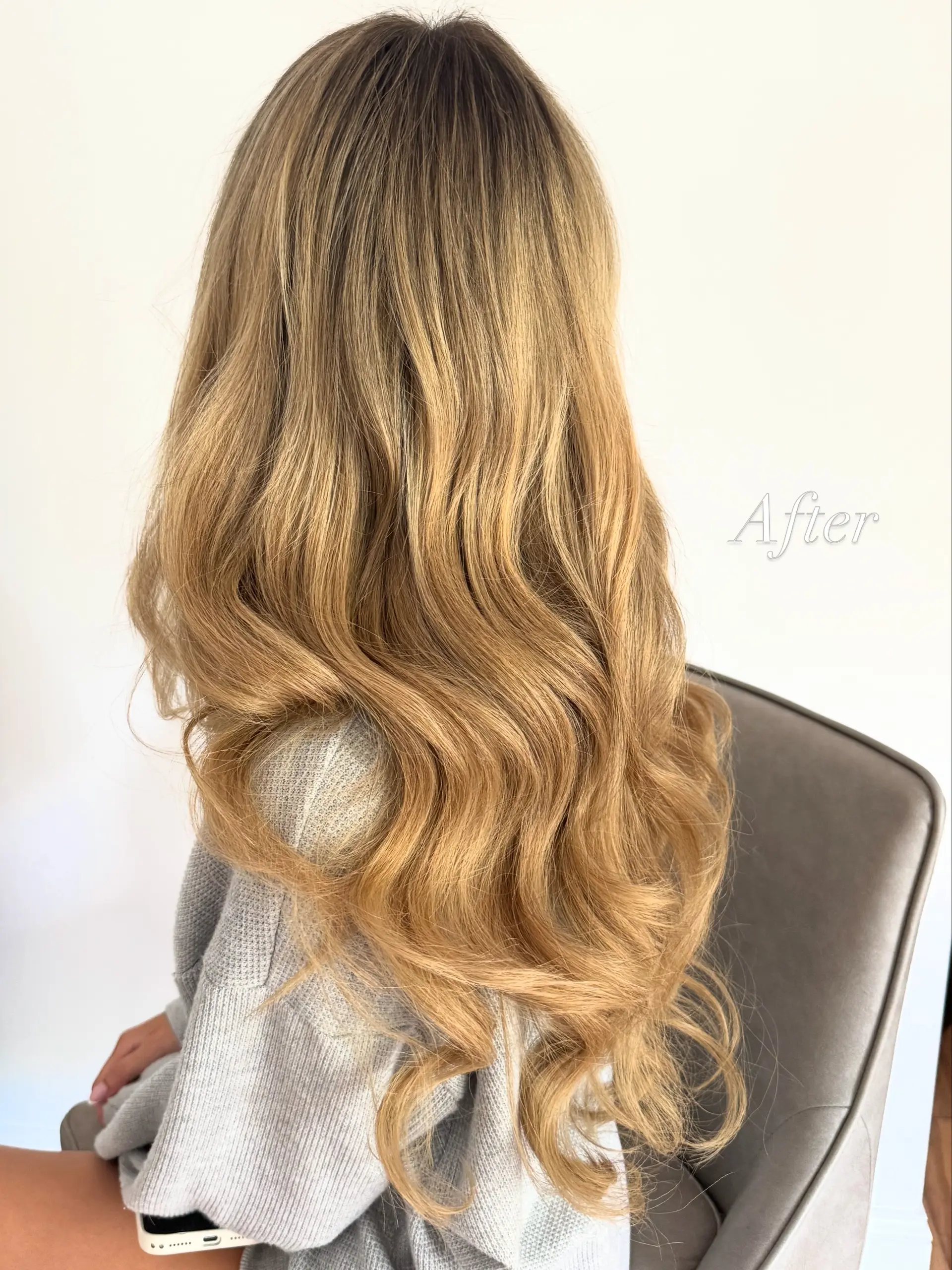 Extra long warm blonde hair styled in full, flowing waves with seamless length and volume. 1