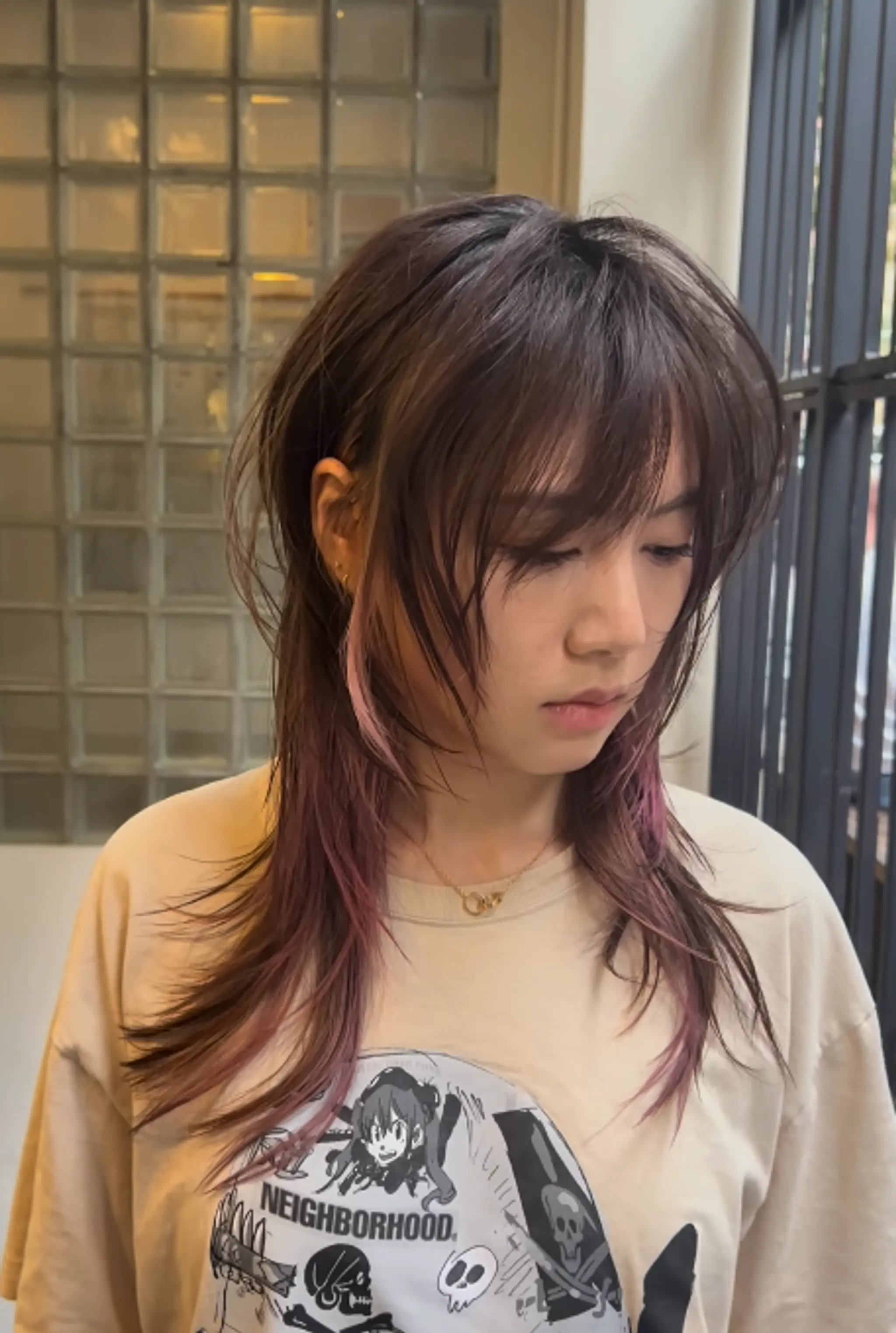 Medium-length, wavy hairstyle with dark brown hair and light pink highlights. Soft cascading layers frame the face, creating a whimsical and elegant look. 1