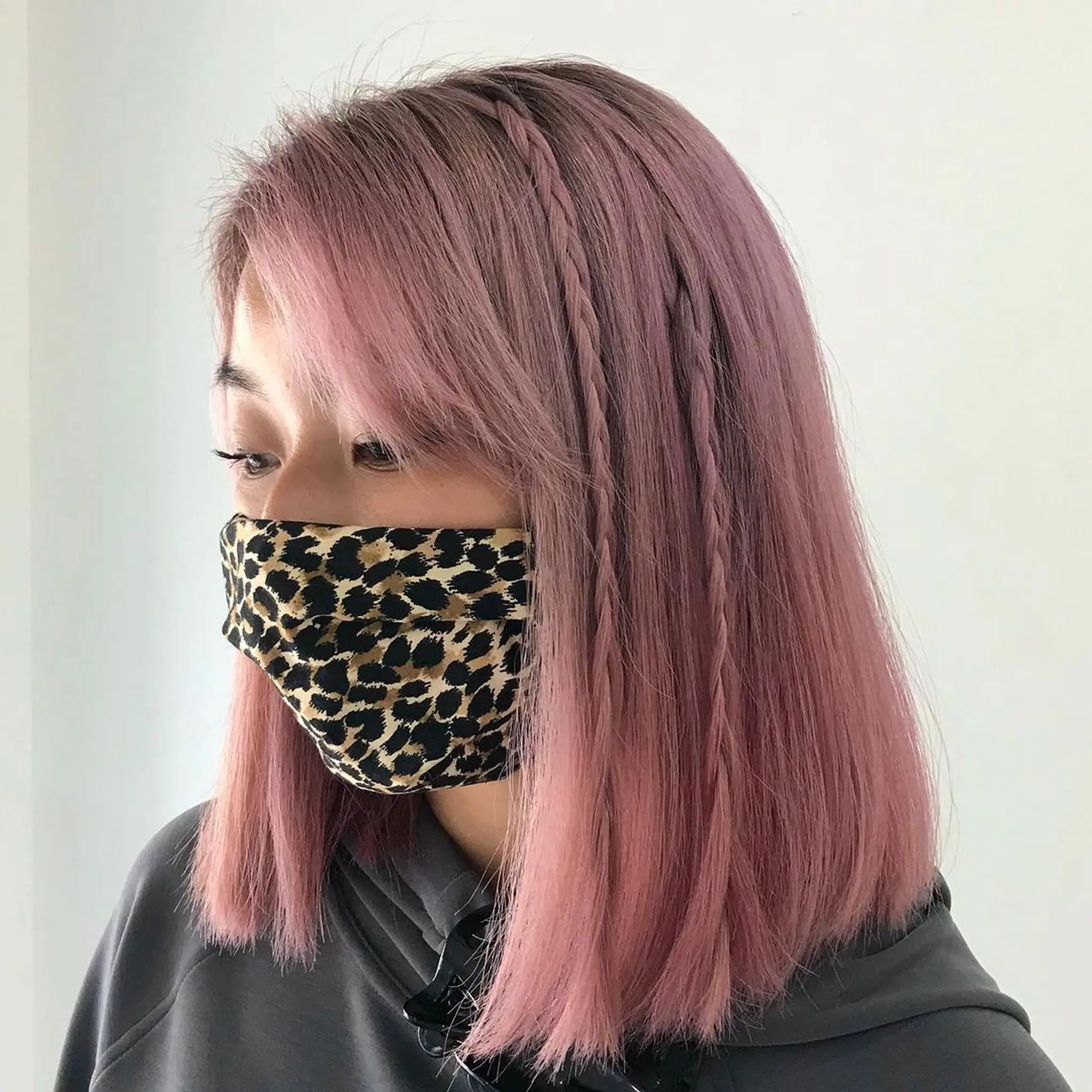 Medium-length straight bob in lilac and pink with layered, intricate braiding on one side.