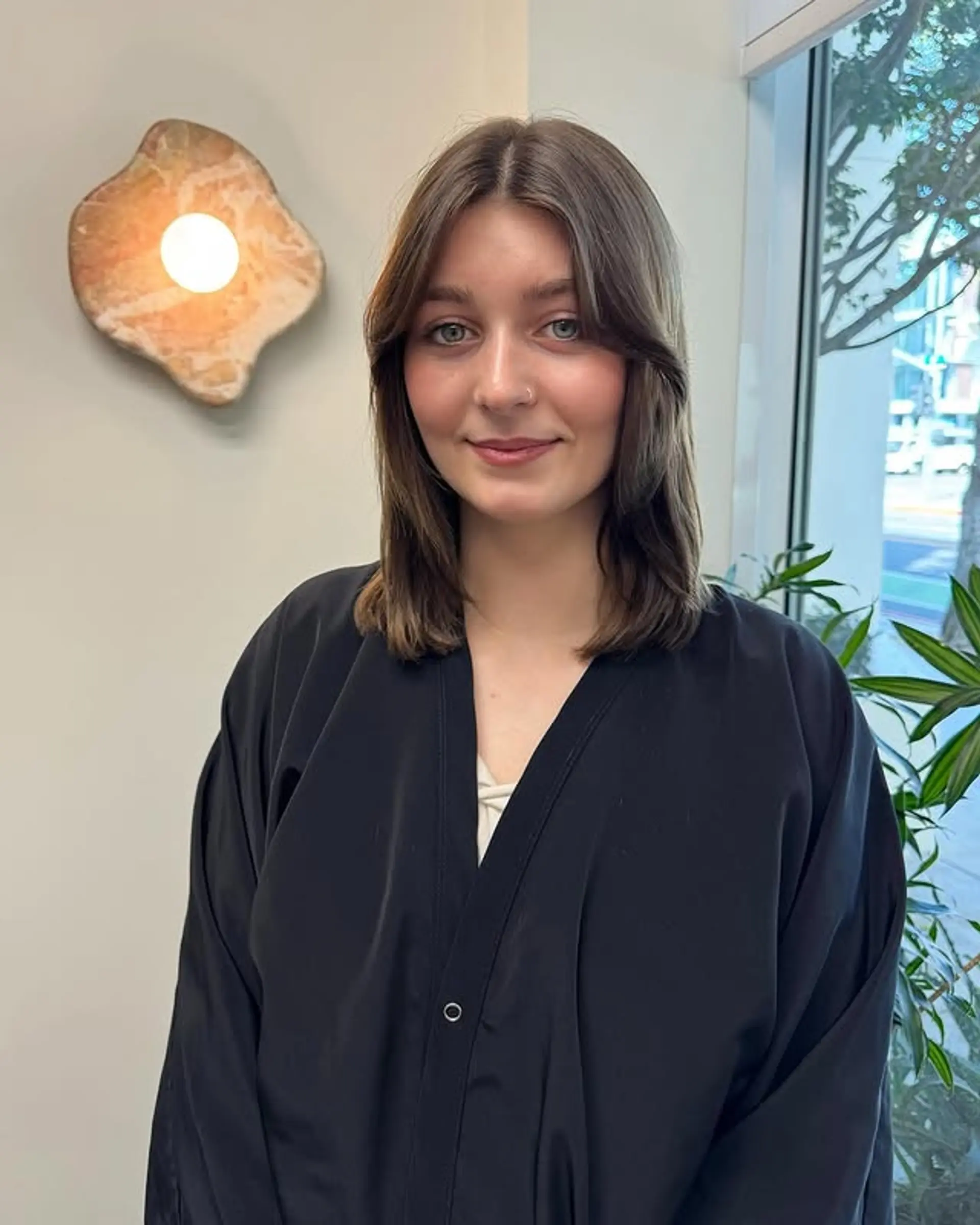 A trendy medium-length layered haircut featuring face-framing curtain bangs for a soft, modern look. 1