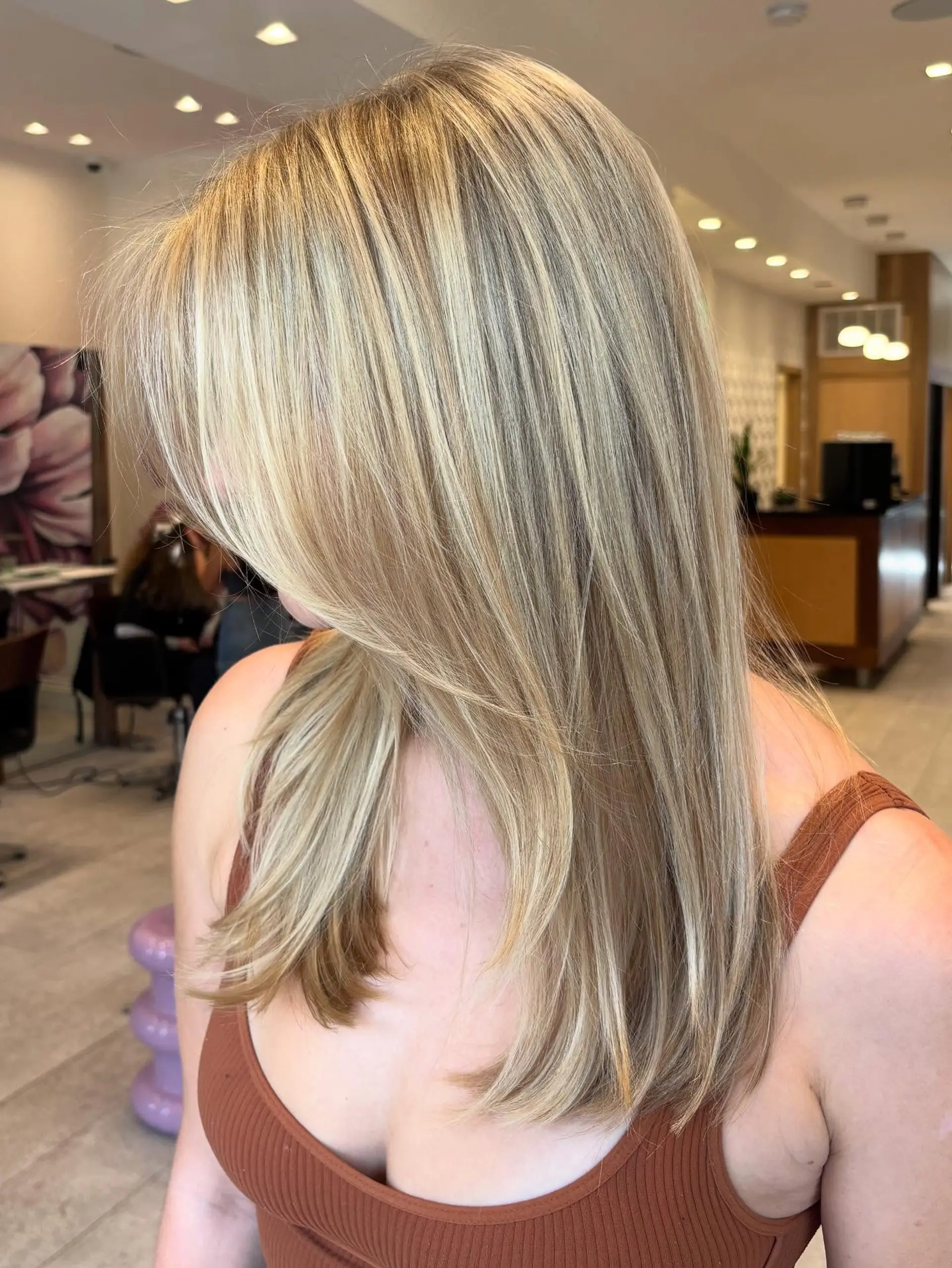 Seamlessly blended multi-tonal butter blonde highlights styled straight with soft inward beveling at the ends. 1