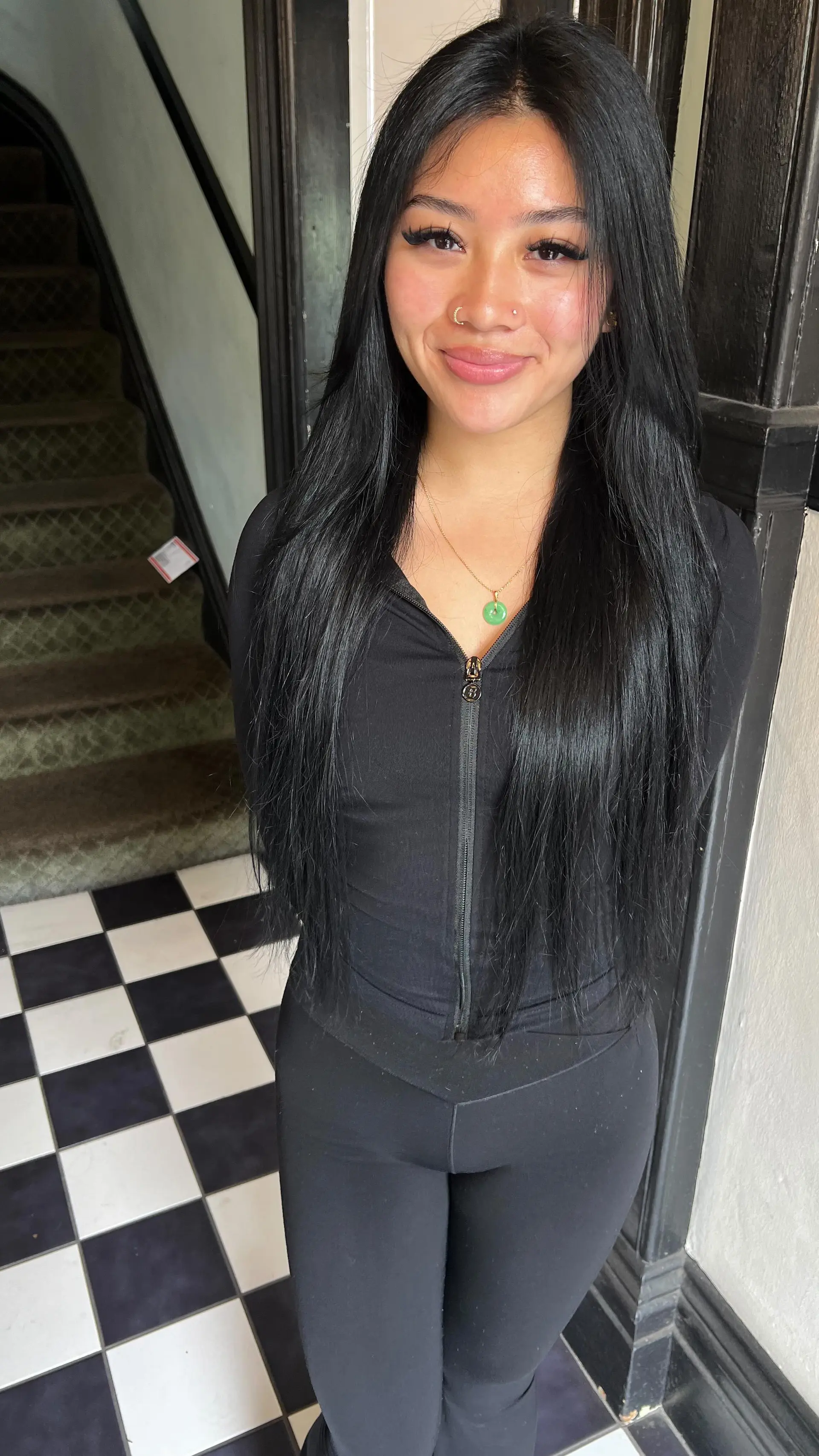 Long, sleek jet black straight hair styled with a center part and extended with seamless I-tip extensions. 1