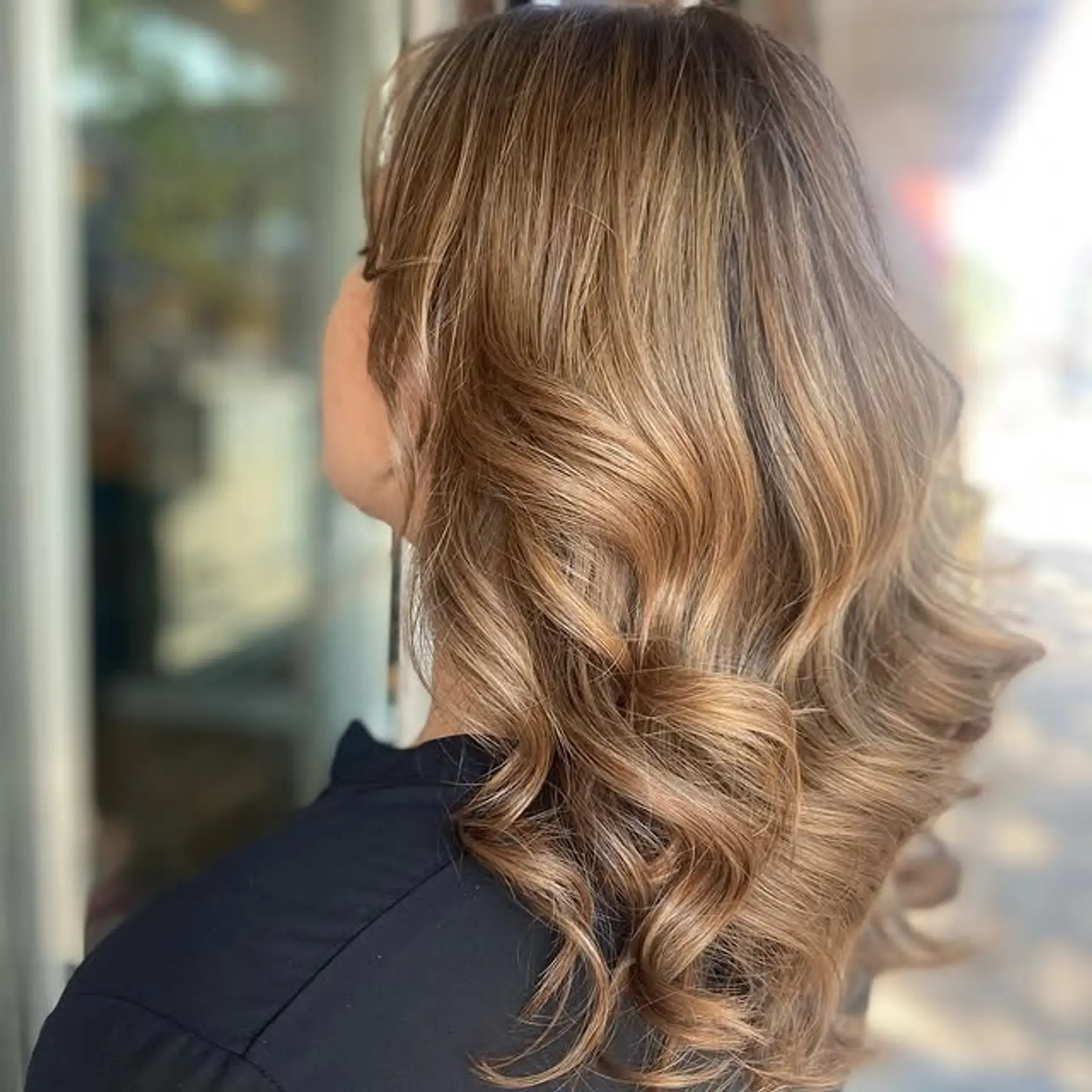 A medium-length wavy hairstyle with a balayage that gives depth and movement. 1
