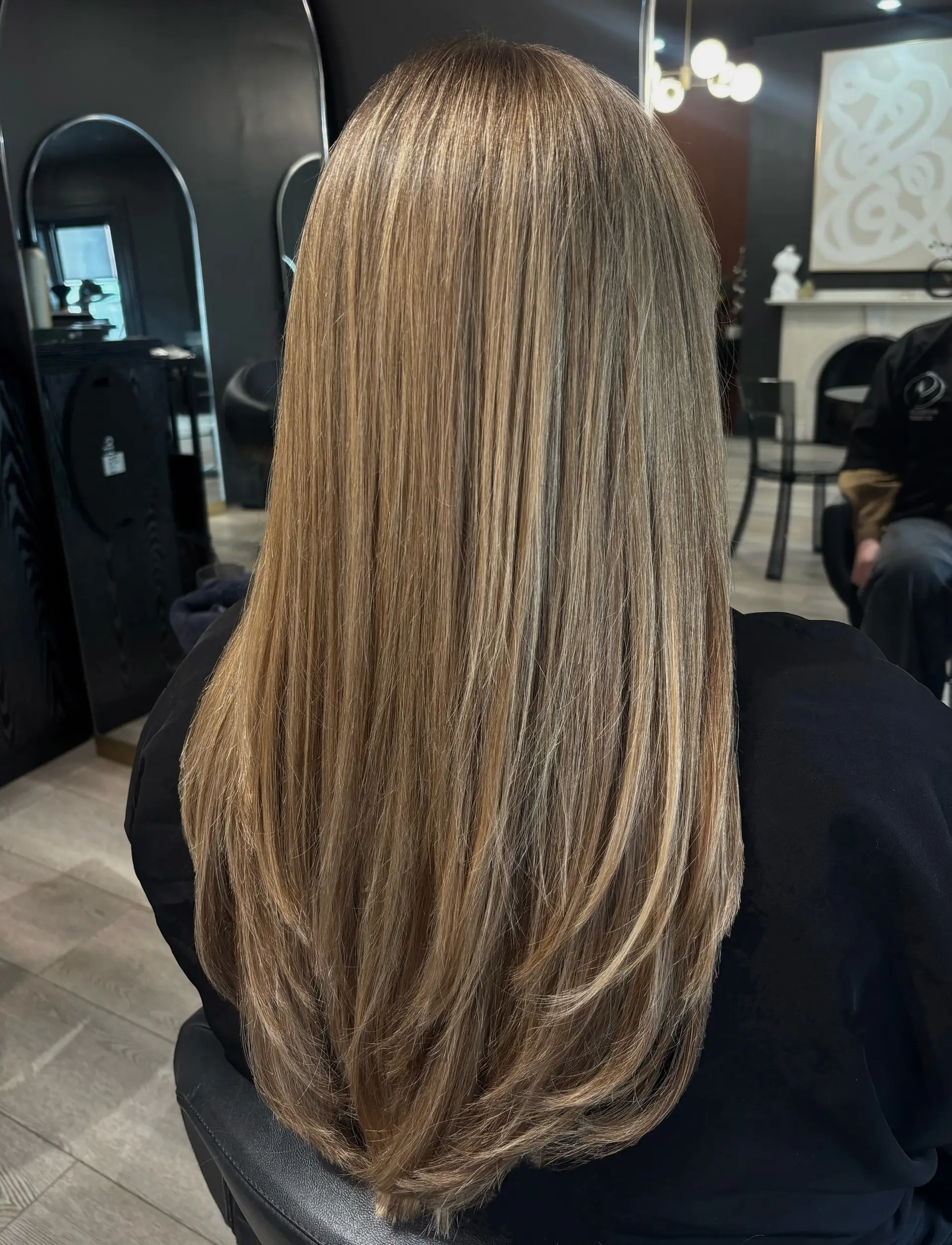 Straight, smooth long bronde hair featuring finely blended multidimensional highlights with soft face-framing and layered ends. 1