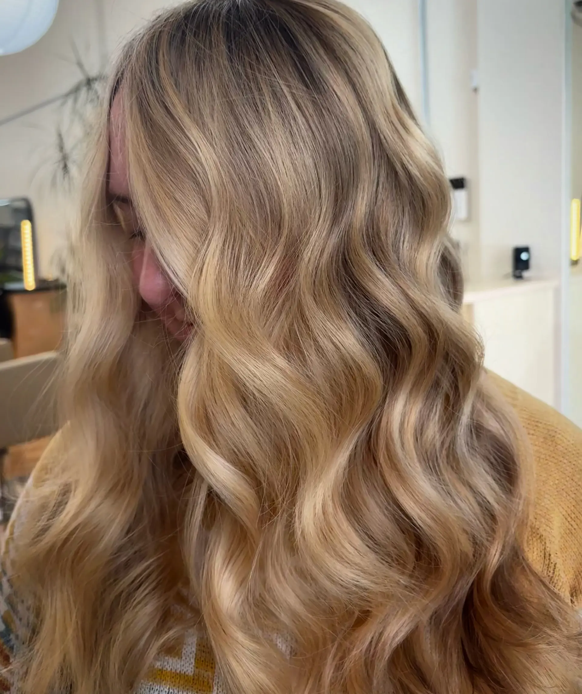 Long, warm golden blonde hair styled in soft, defined cascading waves. 1