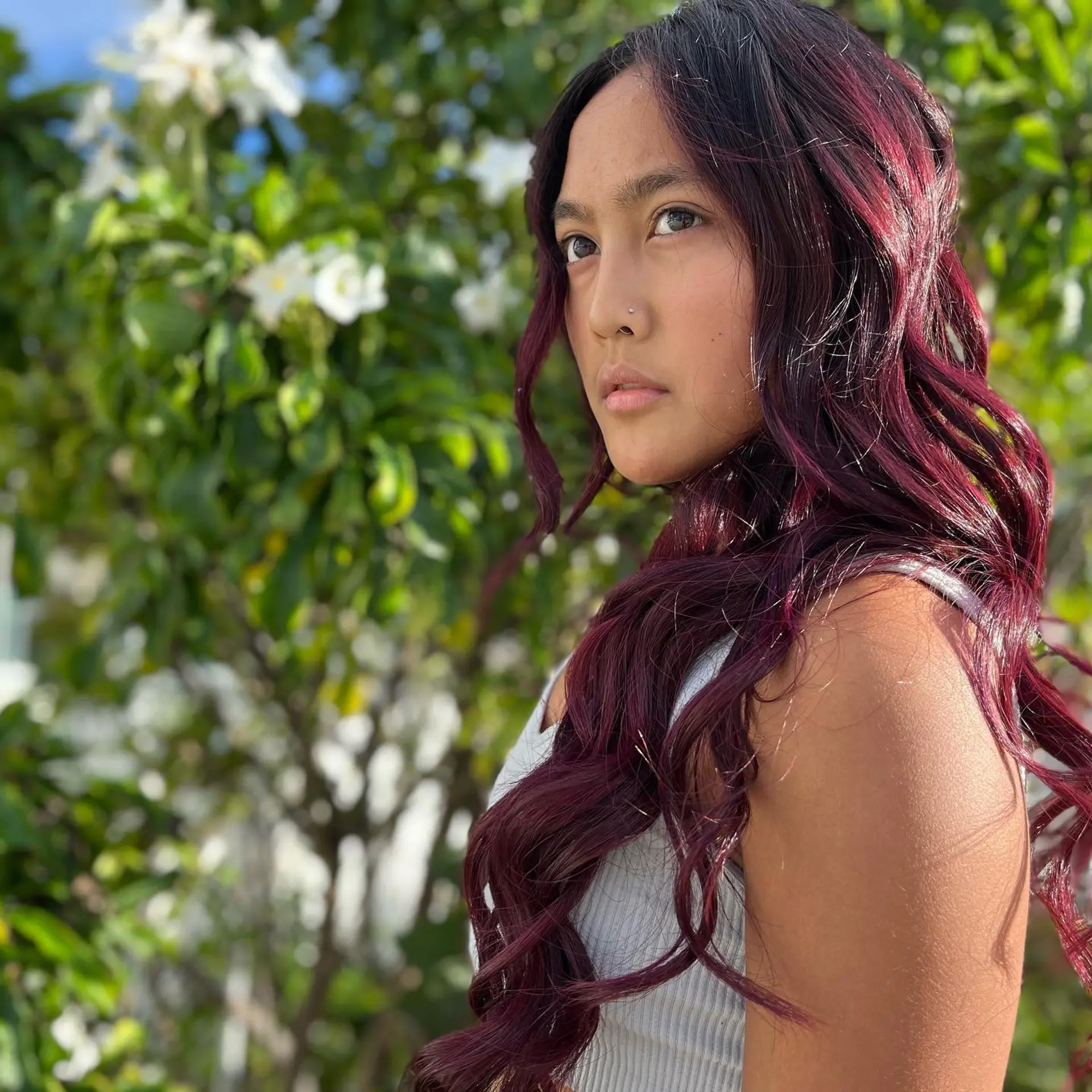 Long, wavy hair with a trendy burgundy color and dark roots. 1