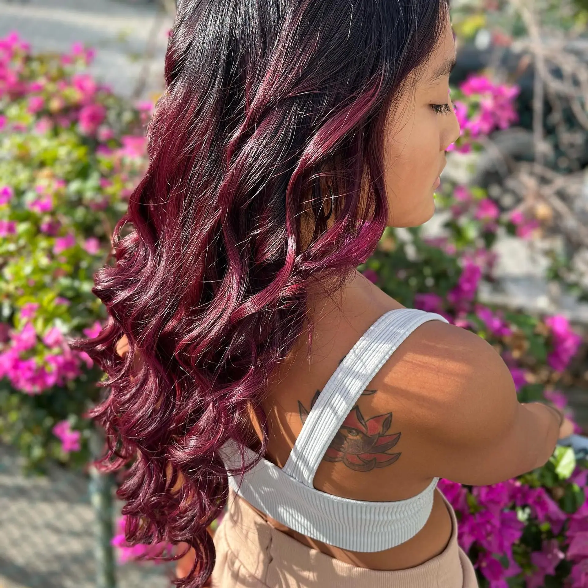 Long, wavy hair with a trendy burgundy color and dark roots. 6