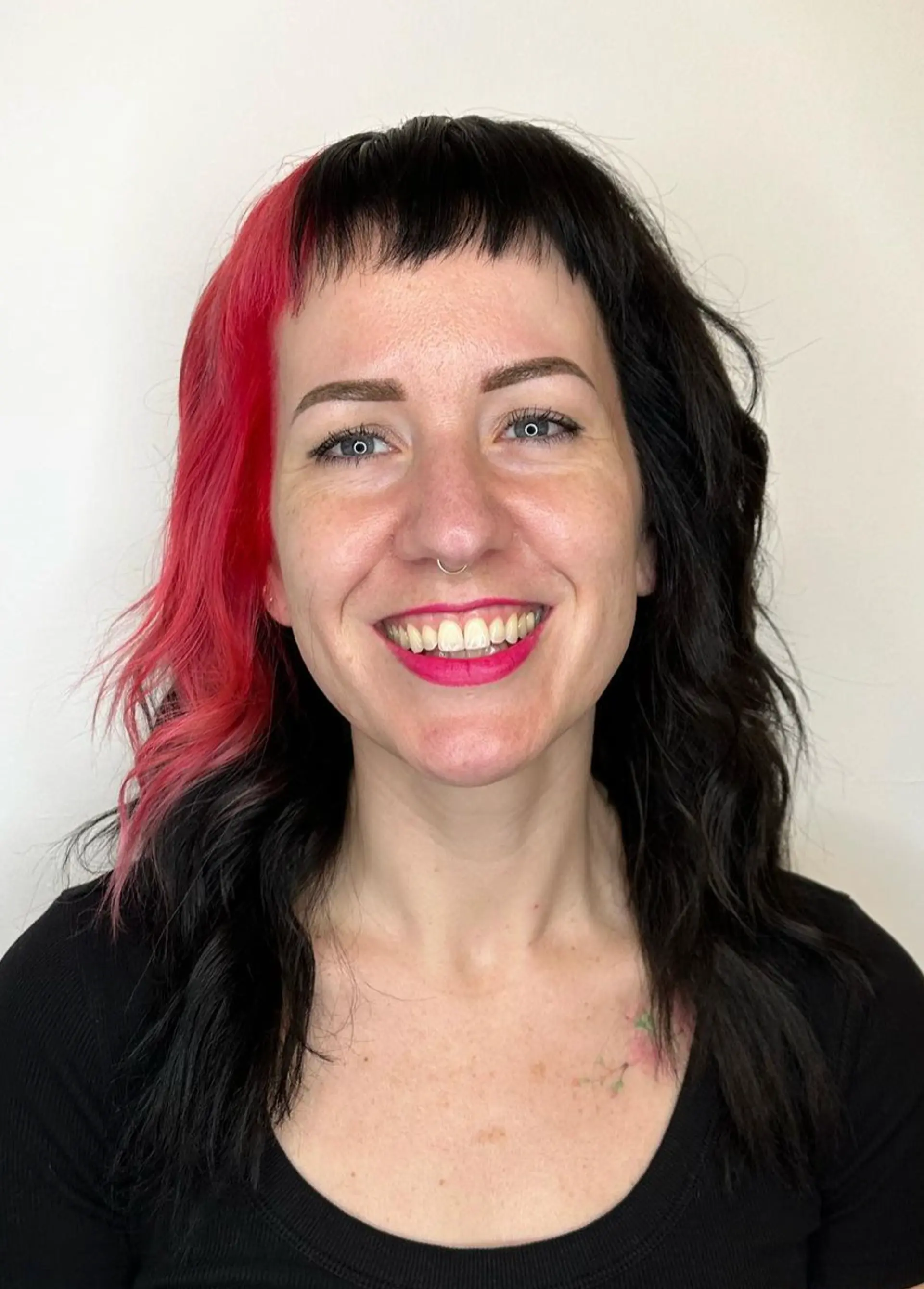 Medium length wavy hair with a two-tone color scheme of black and red, featuring choppy bangs above the eyebrows for an edgy look.

Color by @simabeautynyc
 1